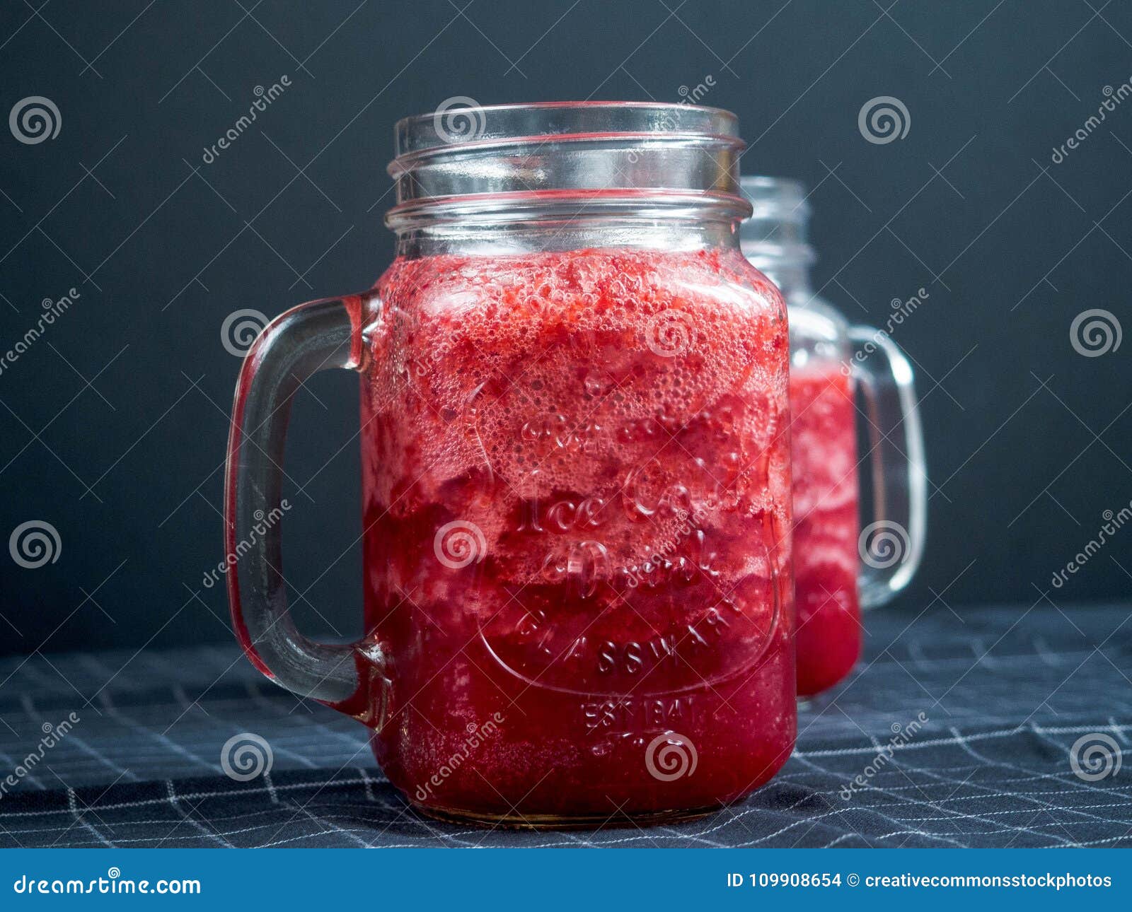 Download Closeup Photography Of Two Clear Glass Jar Filled With Red Liquid On Top Of Blue And White Tattersal Textile Picture Image 109908654 Yellowimages Mockups