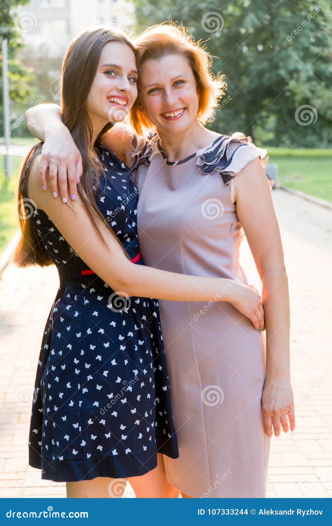 Closeup Portrait Of Adult Daughter And Mother Outdoors Pretty Brunette And Her Mom Are Looking 