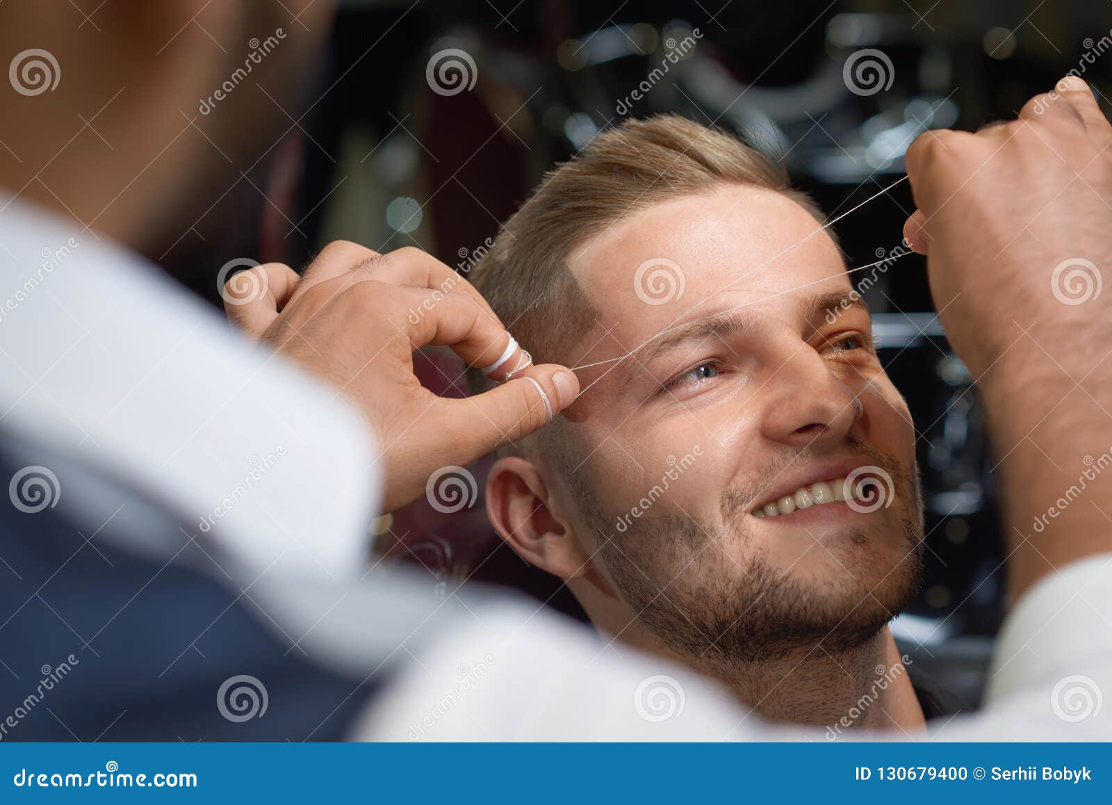Closeup of Process of Threading Procedure in Barber Shop Stock Photo