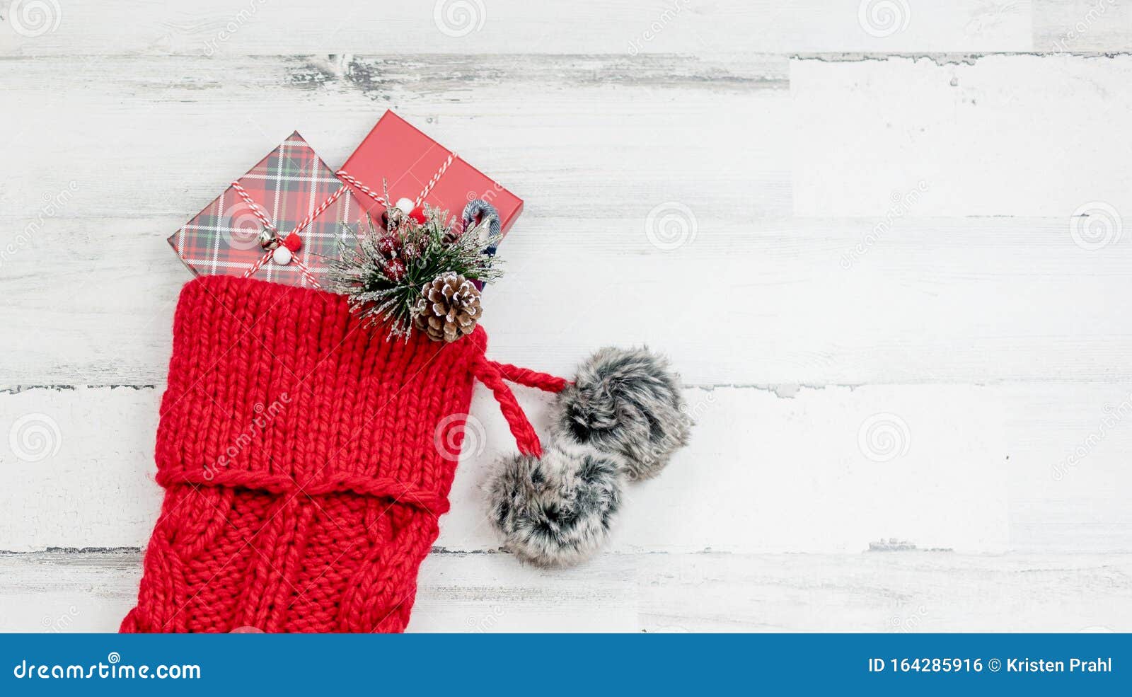closeup of red knit christmas stocking on white wood background