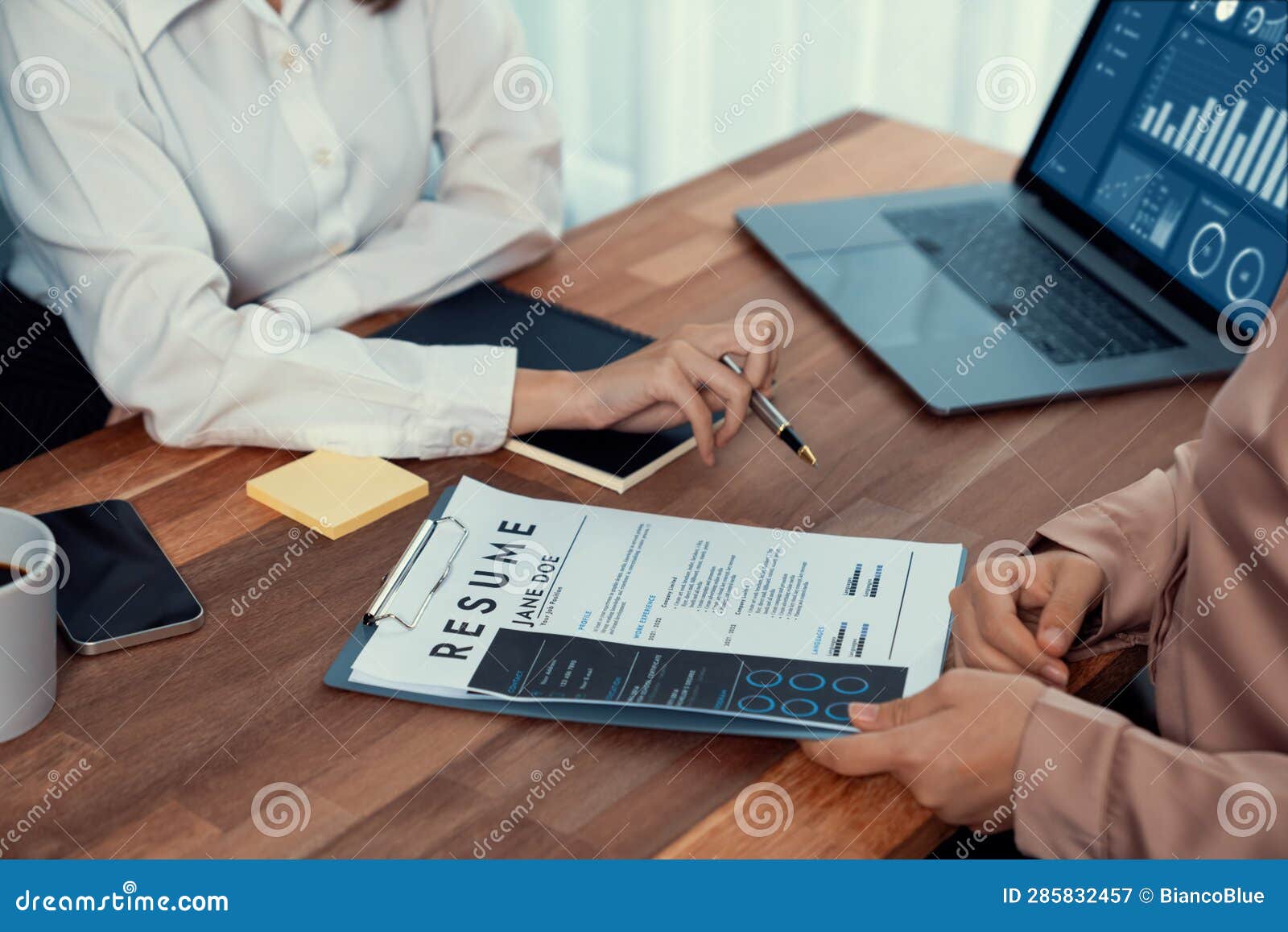 Closeup Resume Paper with Qualifications on Desk during Interview