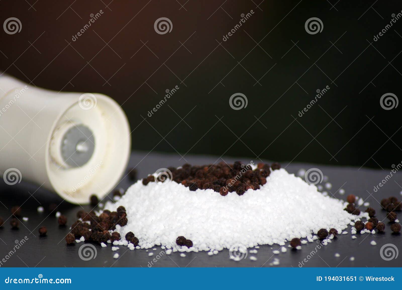 Closeup Shot of Coarse Salt and Pepper Grains on a Smooth Surface Stock