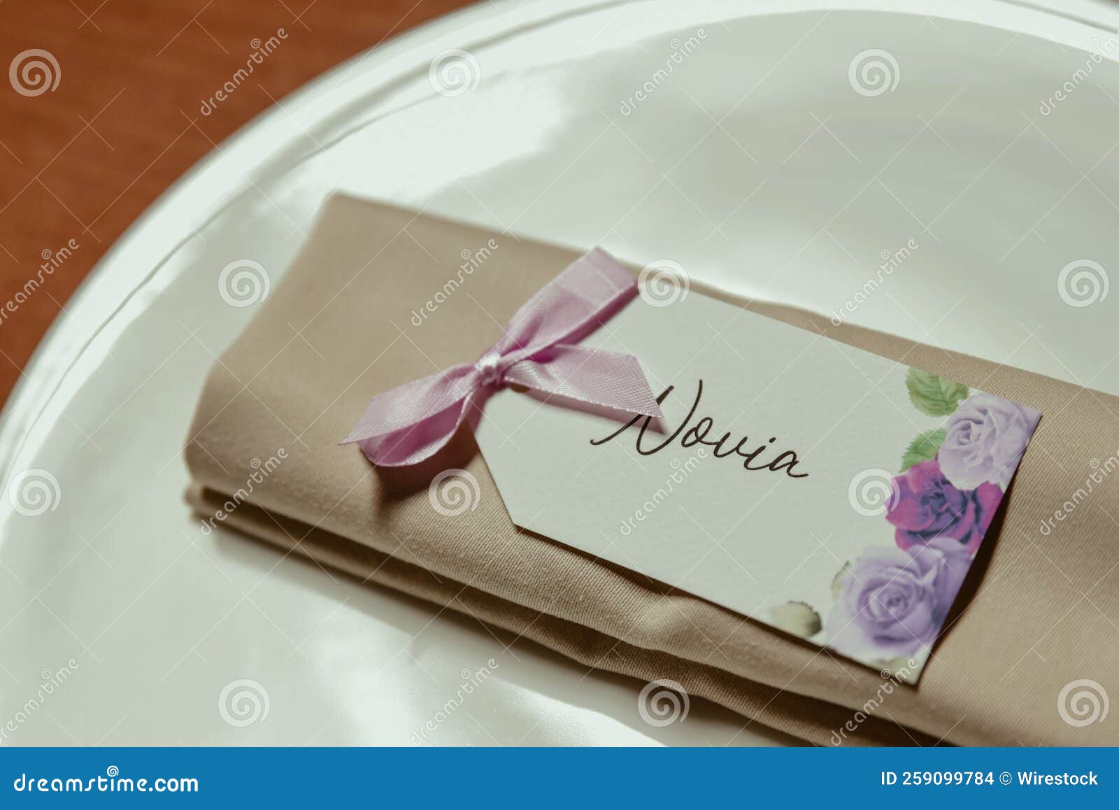 closeup shot of a floral novia name tag on a cloth in a plate