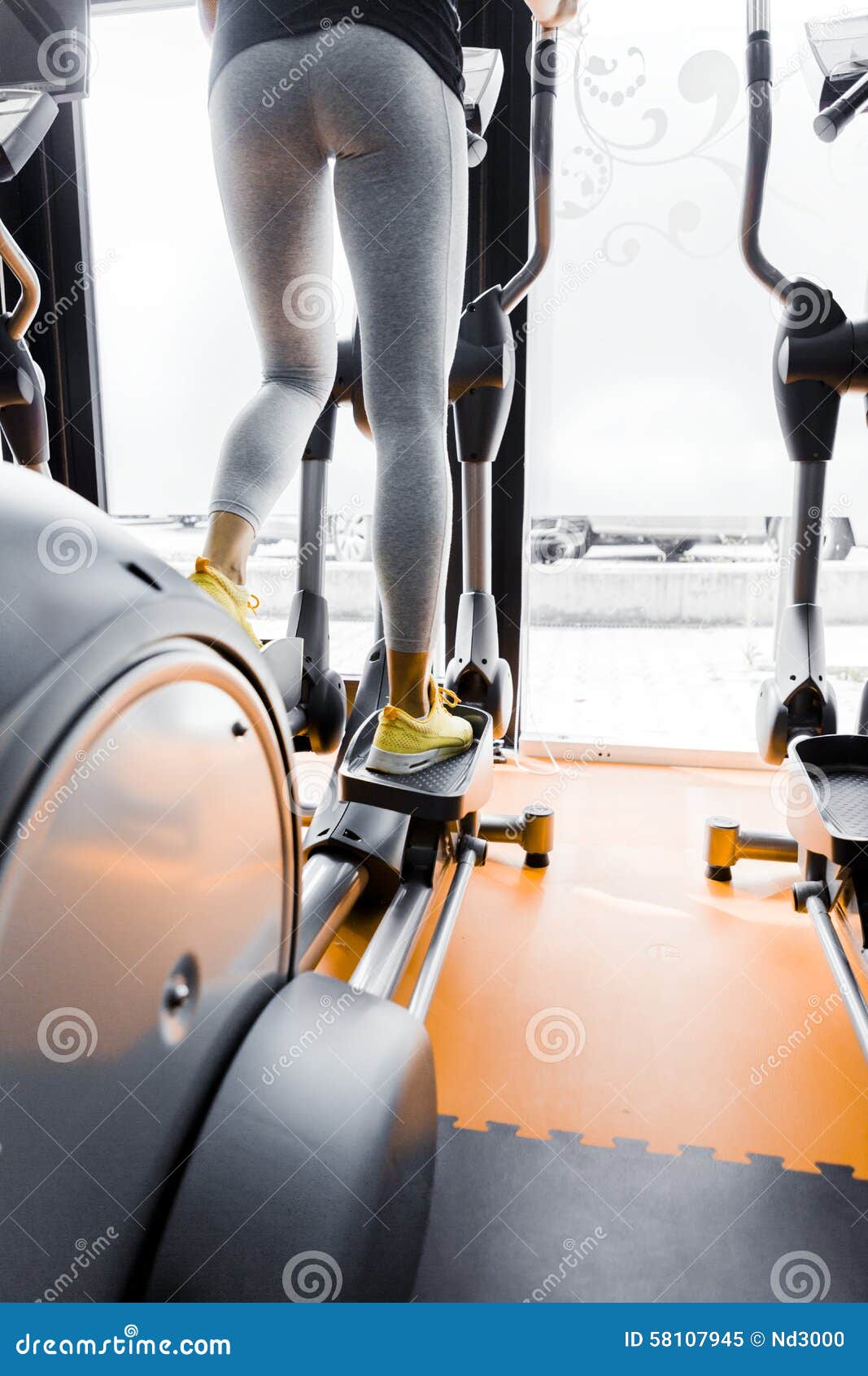 Closeup Shot of Legs of a Female Using Elliptical Trainer Stock Image