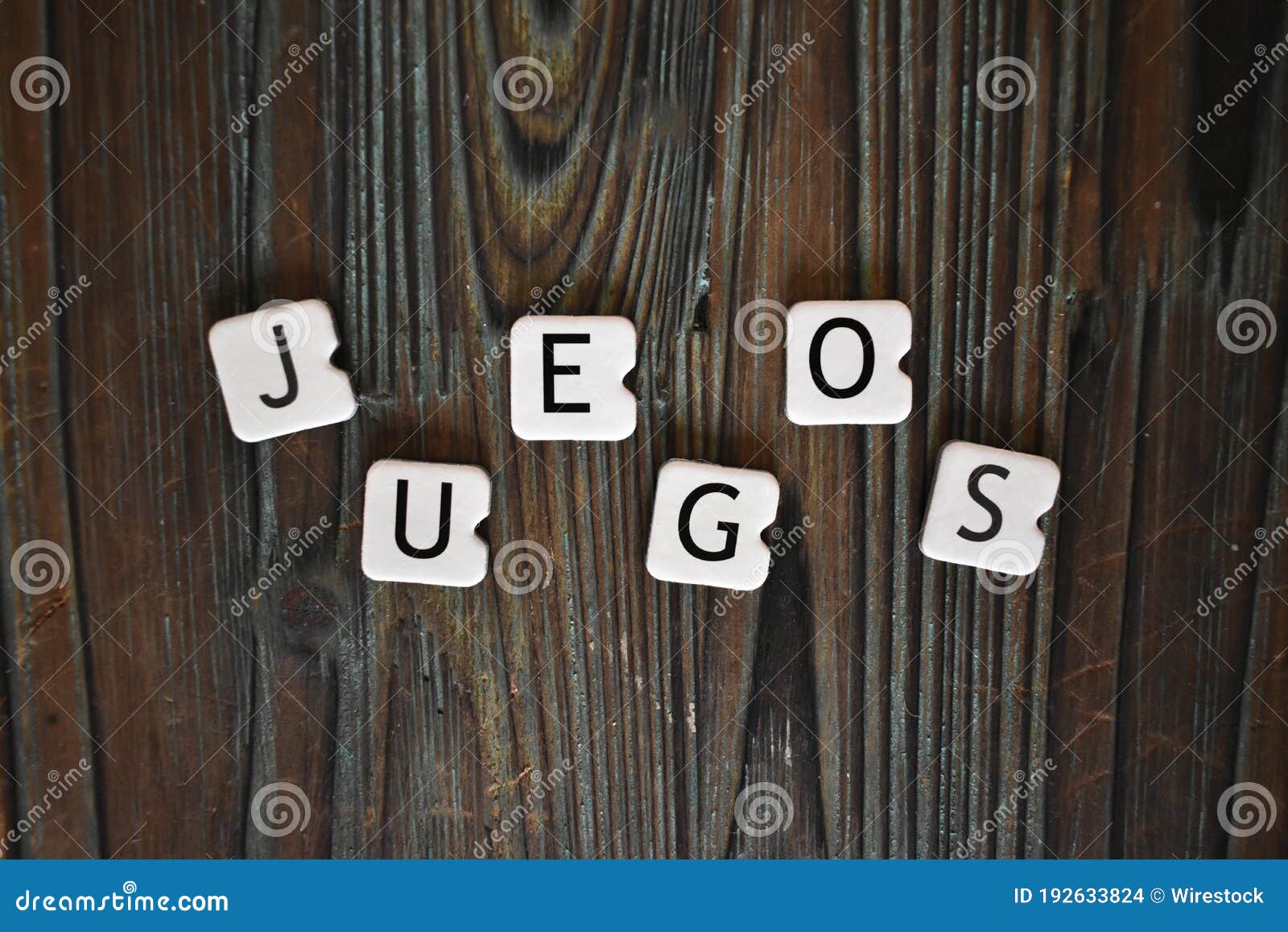 closeup shot of letters cubes forming the word juegos on a wooden surface