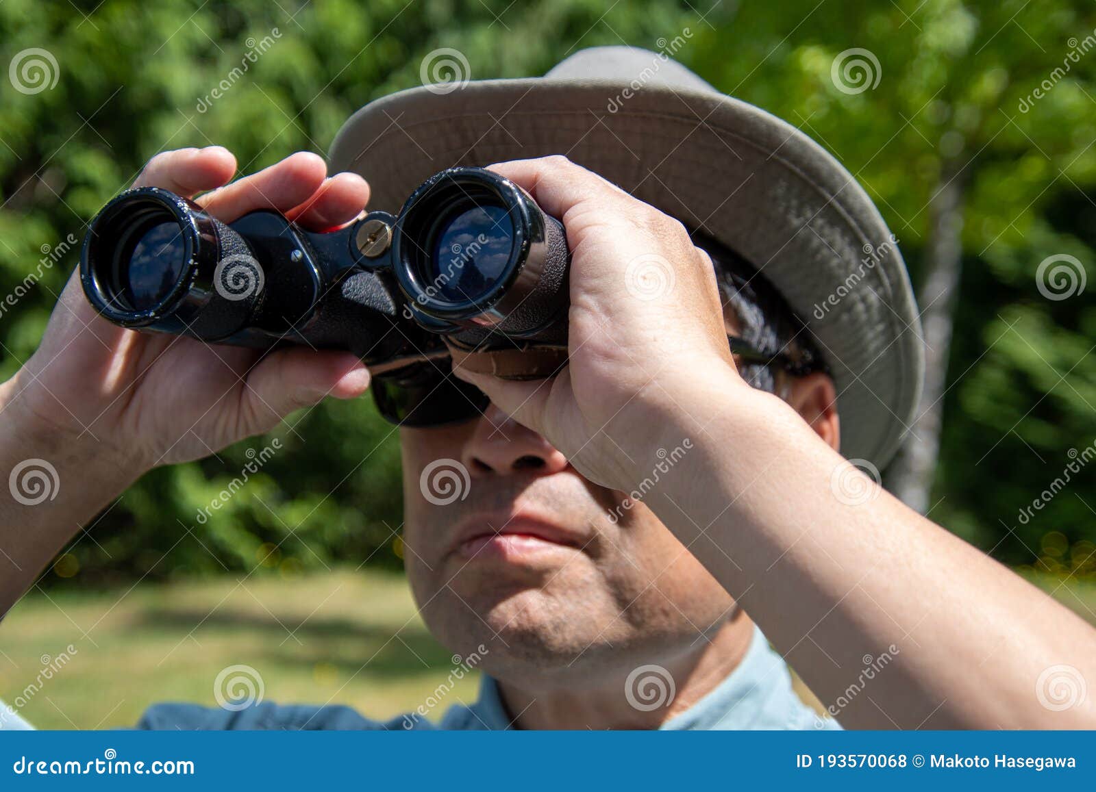 A Closeup Shot of a Man Using a Pair of Binoculars To Look at
