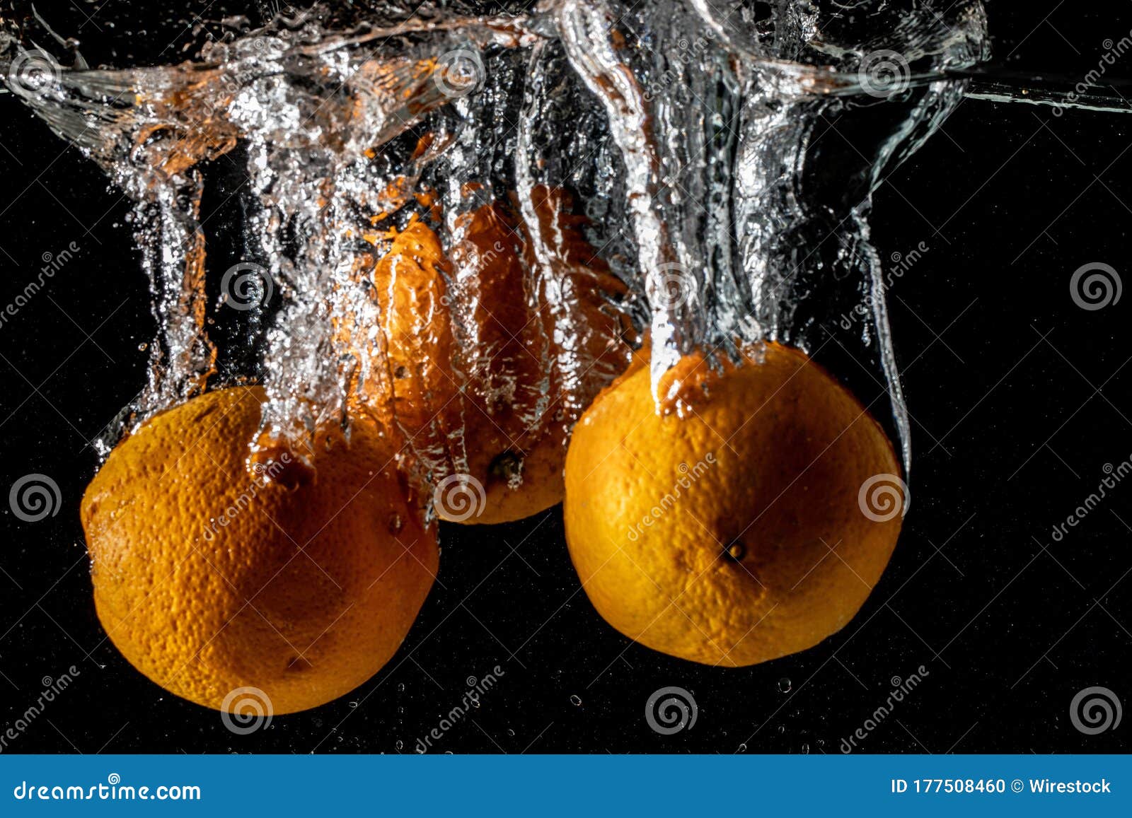Closeup Shot of Oranges Falling in the Water and Making a Splash with a