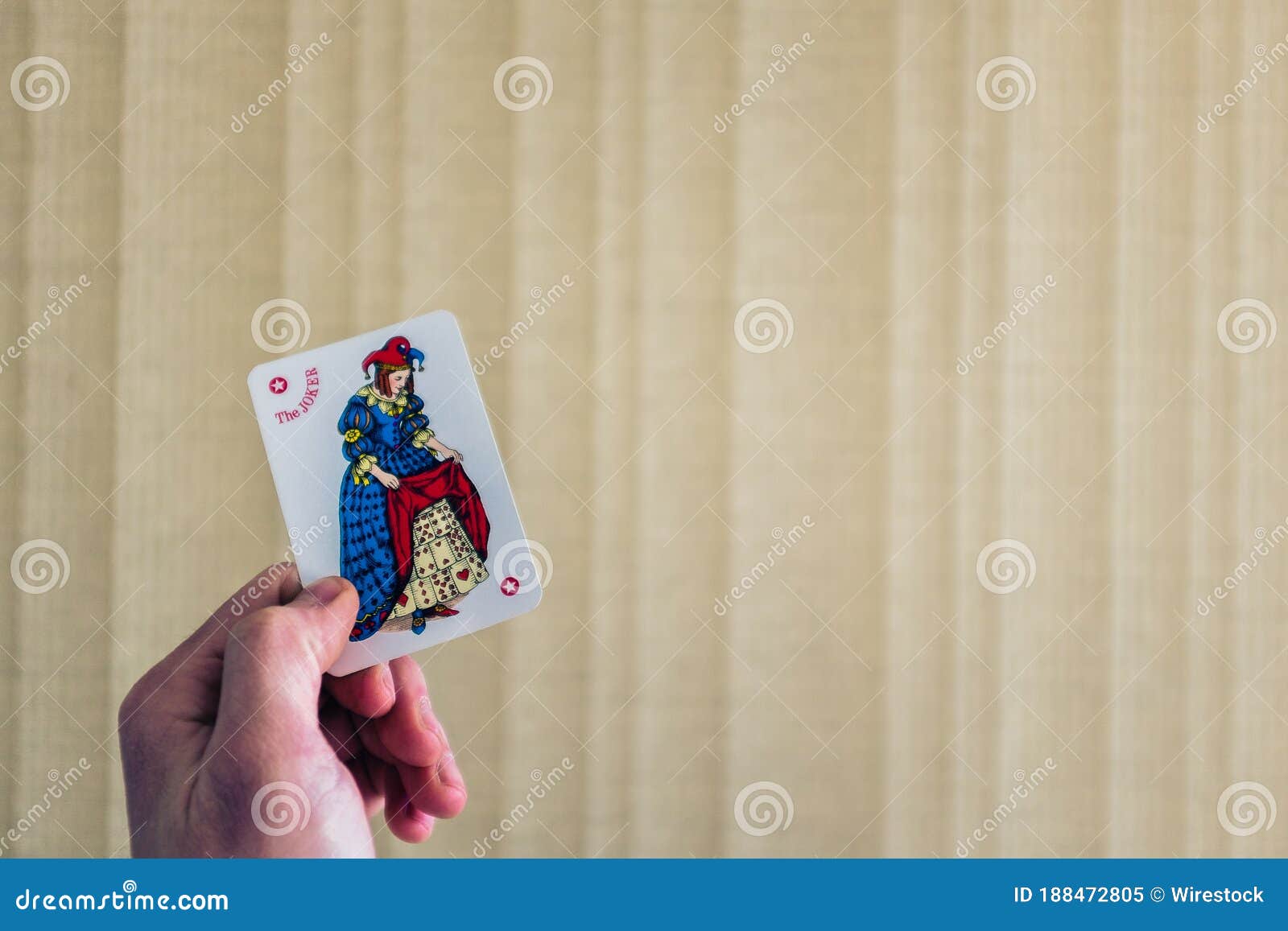 Closeup Shot Of A Person Holding The Joker Card Behind A Light ...