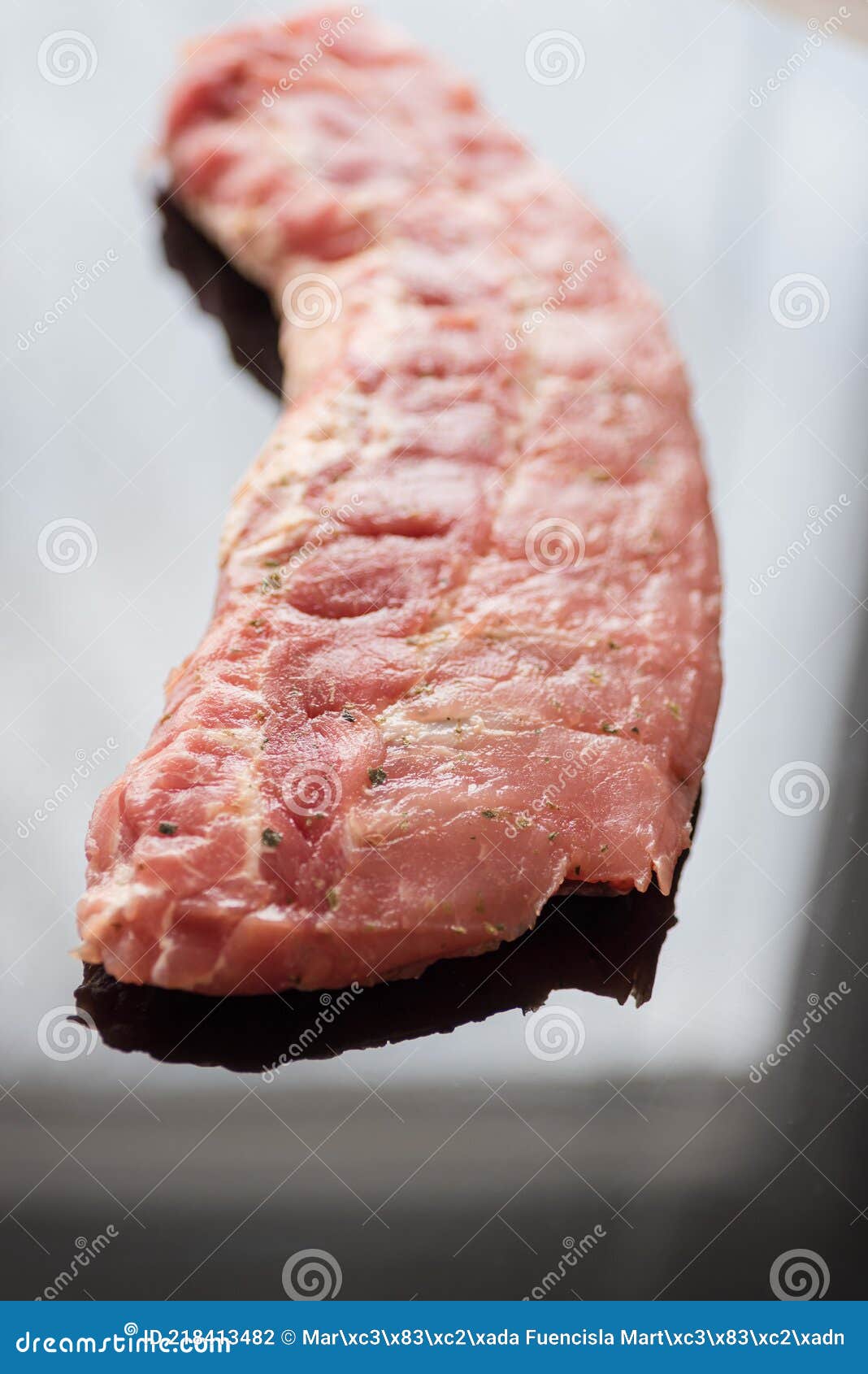 a closeup shot of raw pork ribs being cooked with seasonings