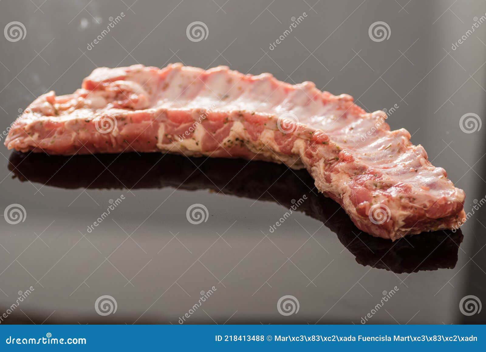 a closeup shot of raw pork ribs being cooked with seasonings