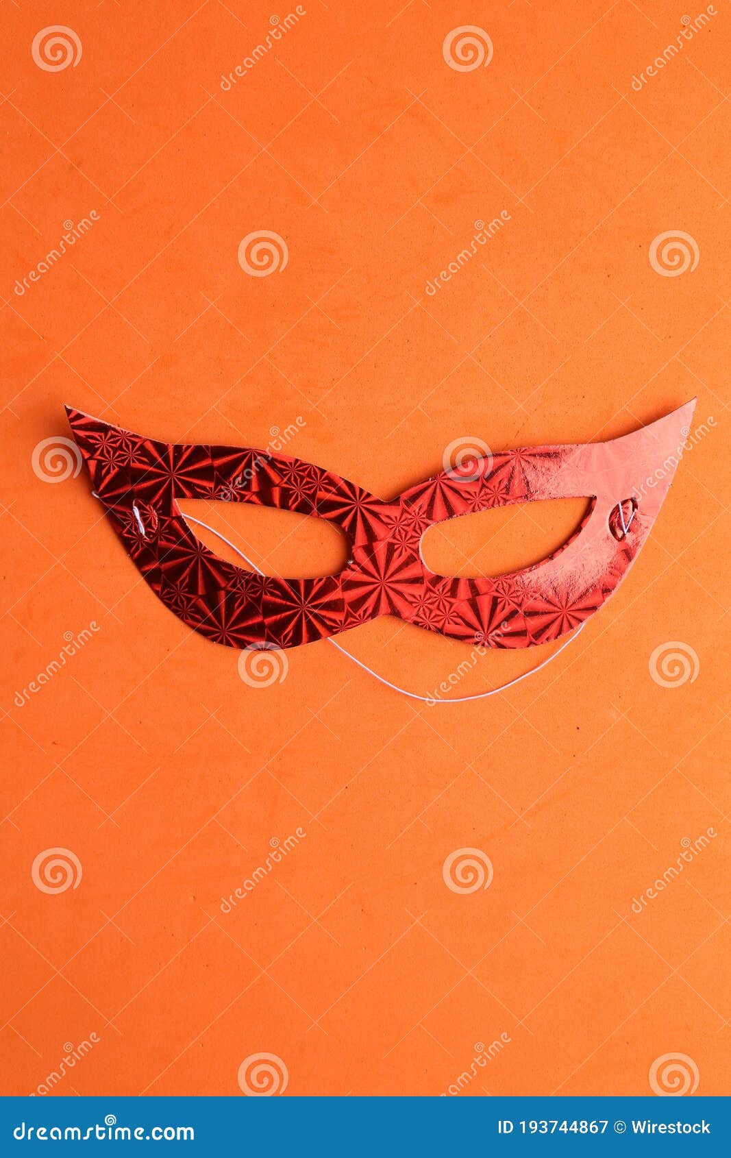 Closeup Shot of a Red Masquerade Mask Isolated on an Orange Background