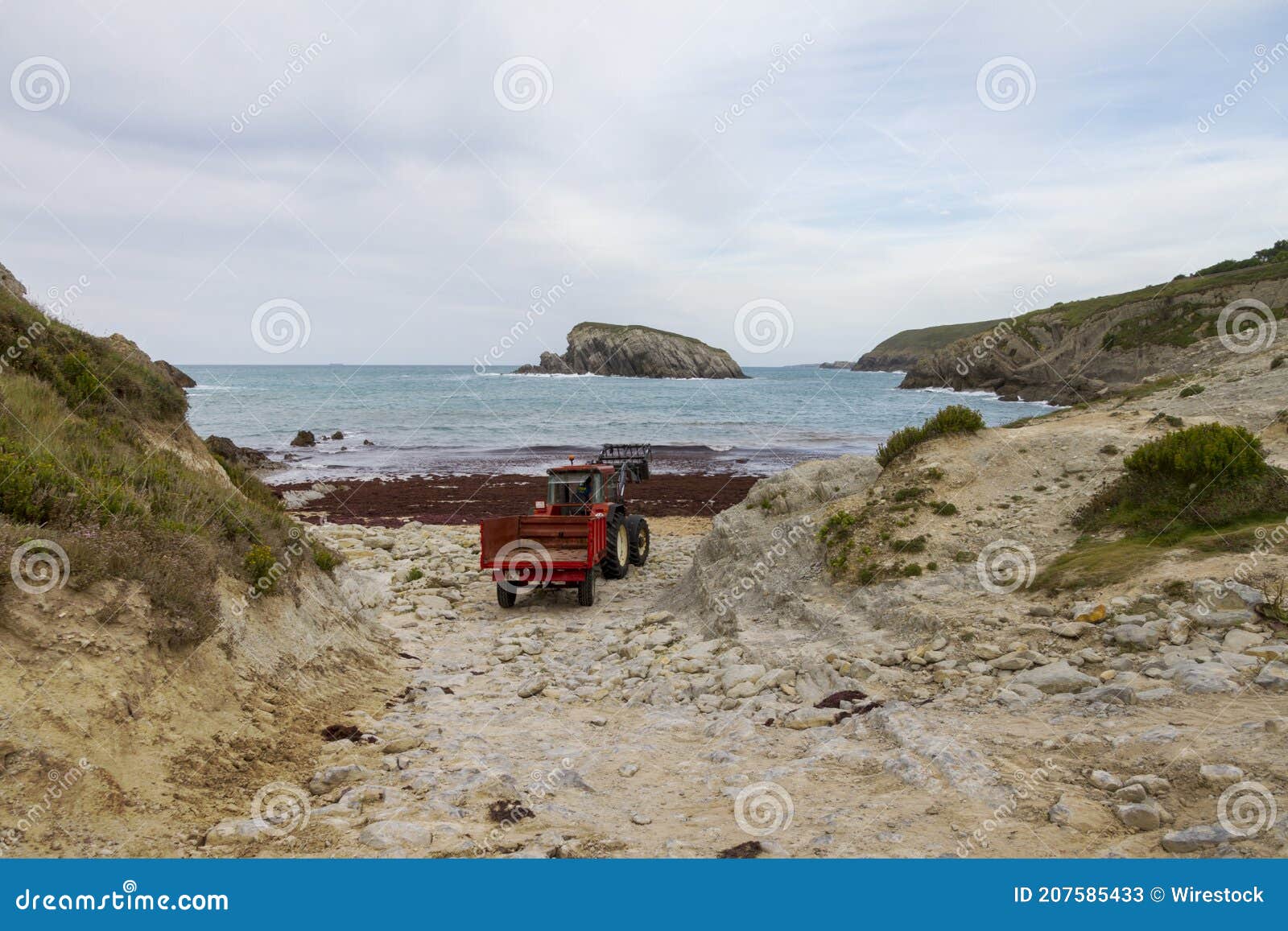 closeup shot of a vehicle on a cliffy seashore near a wavy sea under a cloudy sky