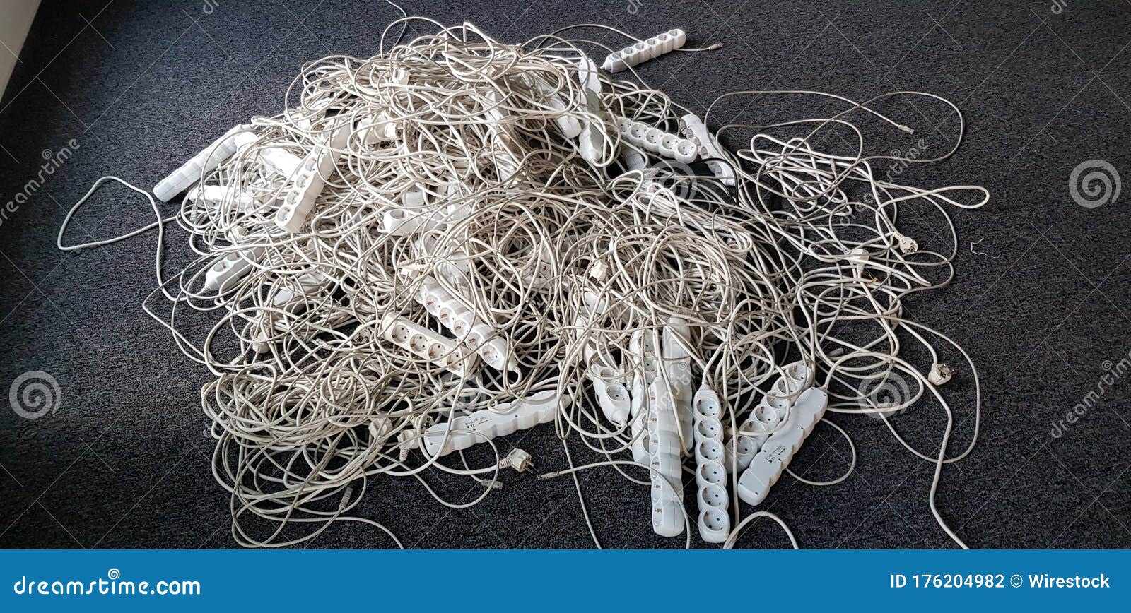 Closeup Shot of White Power Strips and Wires on the Ground Stock Photo