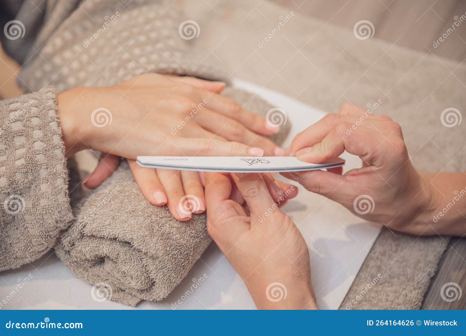 closeup shot of a woman's hands manicuring her client's hands.