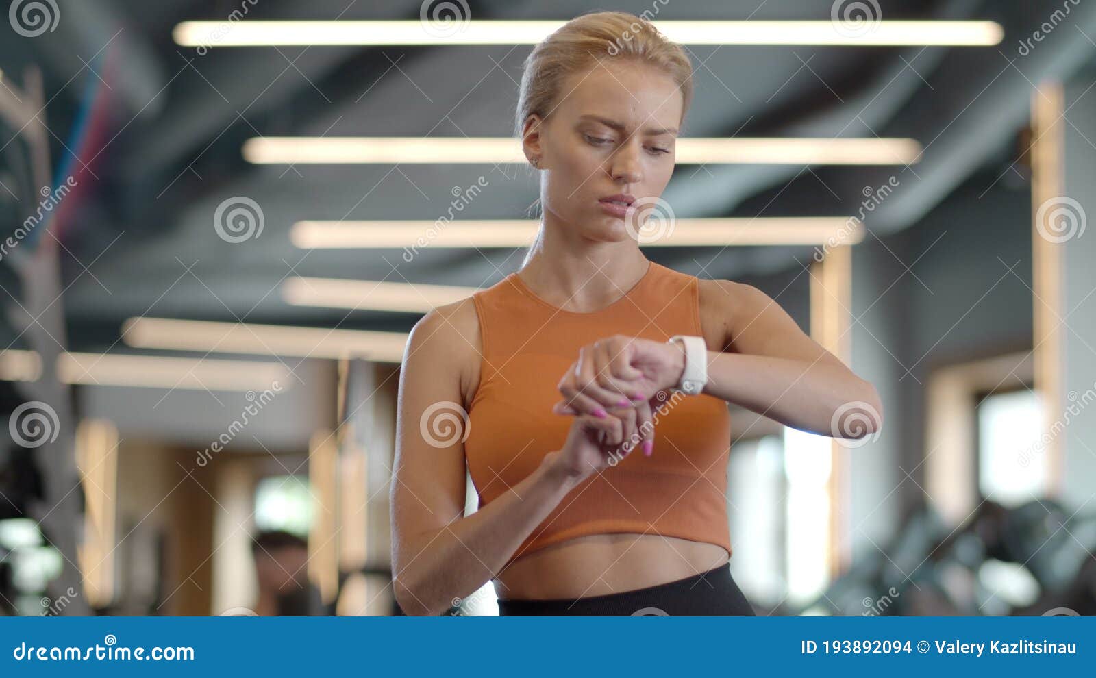 A happy female personal trainer is looking at the sportswoman who