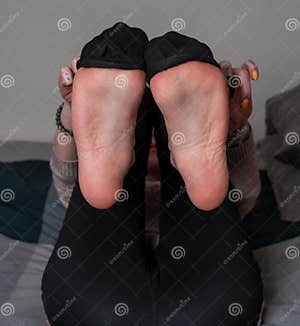 Closeup Of The Soles Of Female Feet With Socks Lying In A Bed Stock 