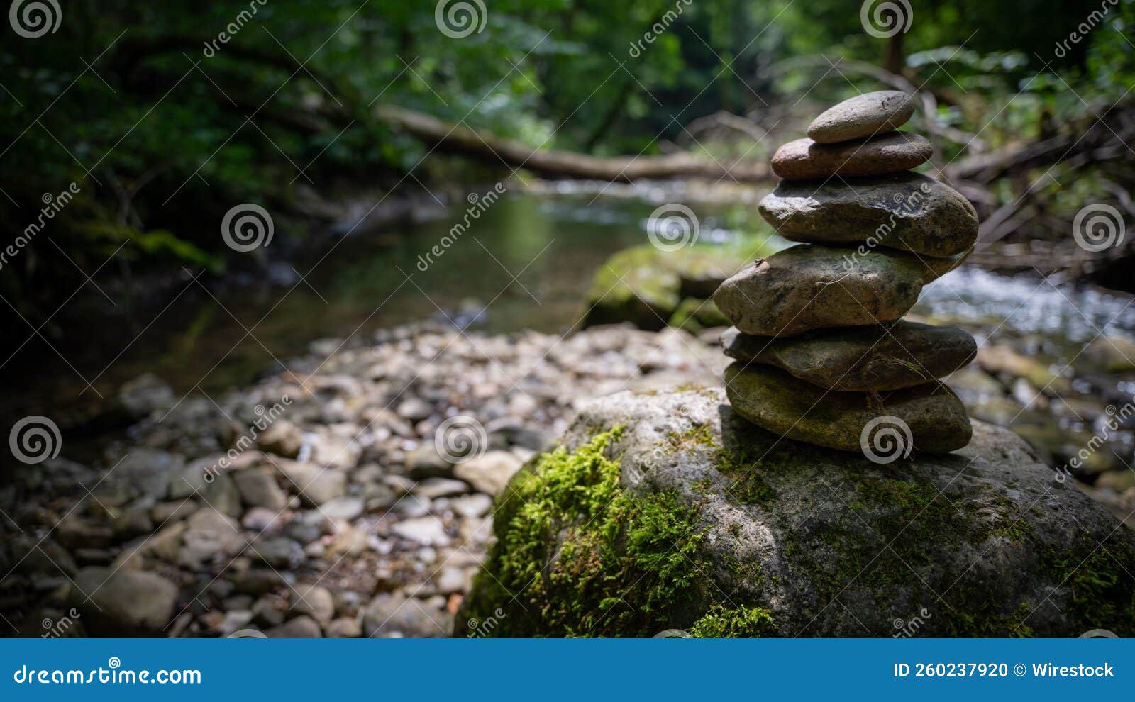 closeup of stacked rocks in background of flowing river