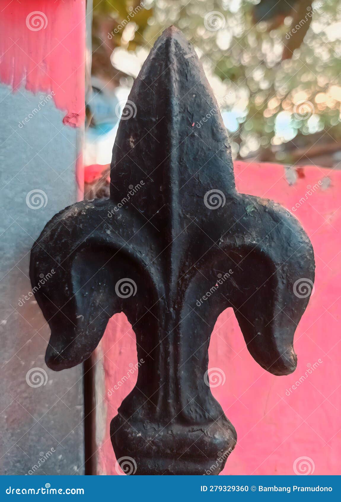 closeup texture detail of decorative  of wrought iron gate with fleur de lis pattern on vertical fence