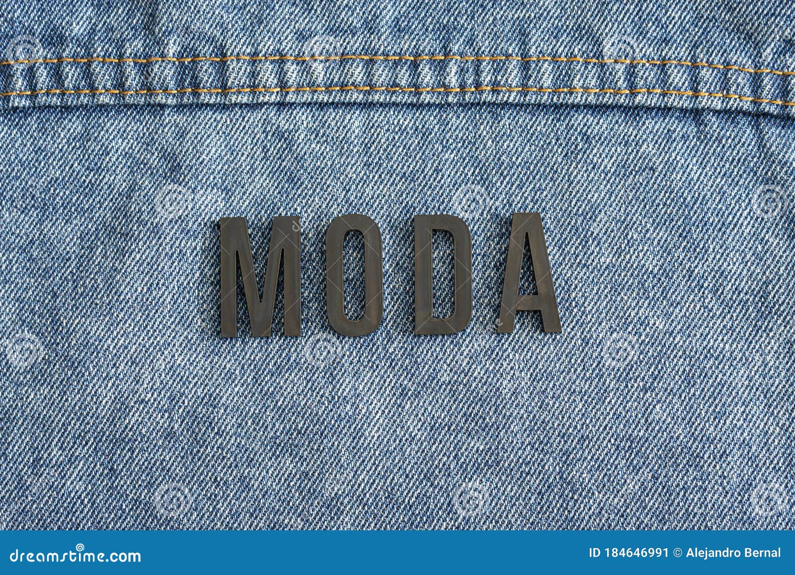 closeup to a fashion word in spanish `moda` lettering black word over a gradient blue jean