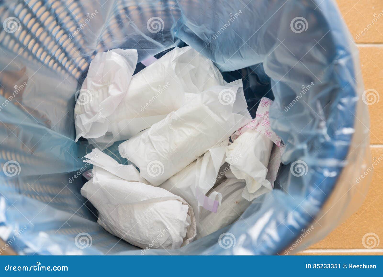 closeup used sanitary napkin pad wrapped disposed in rubbish bin