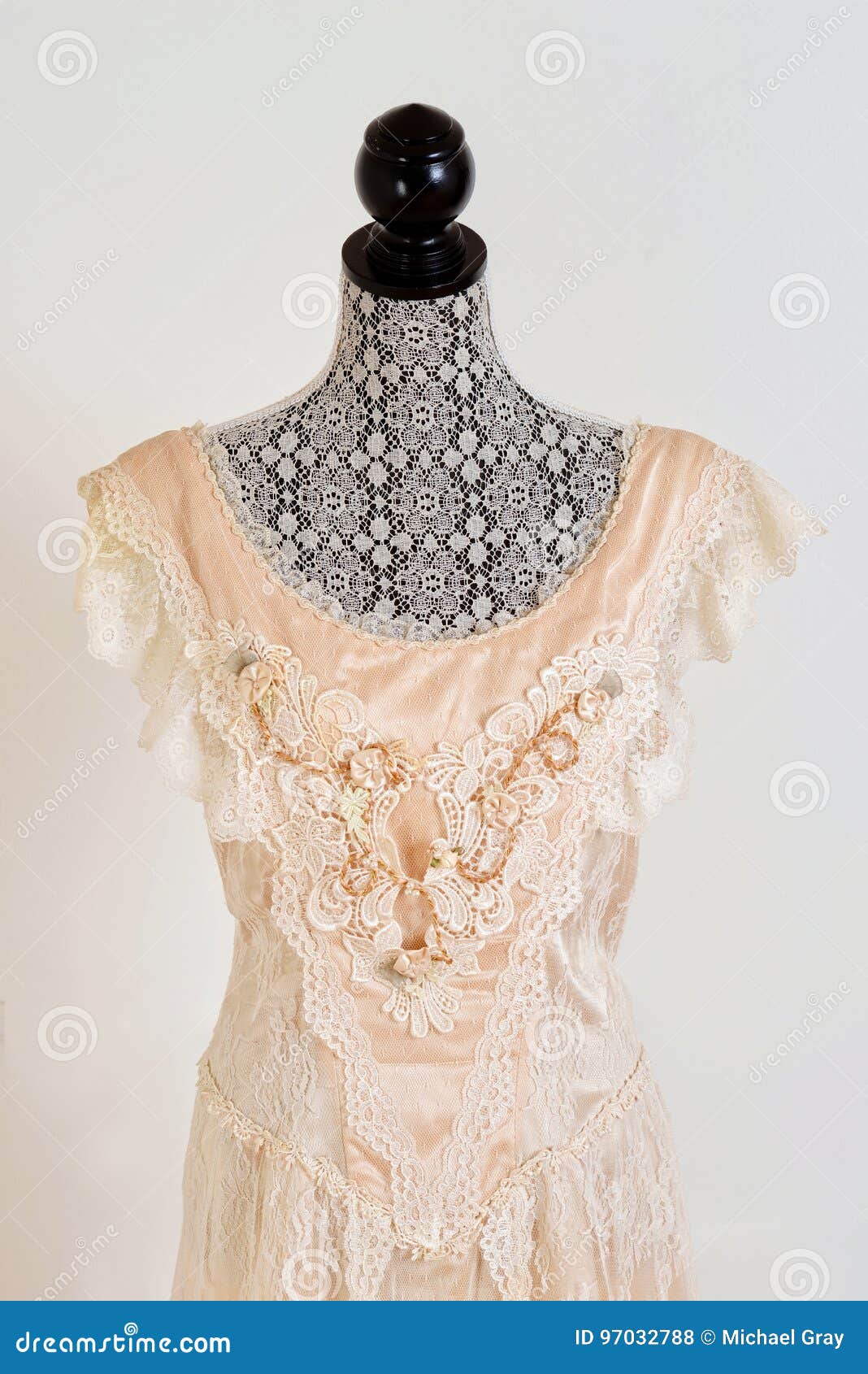 Closeup vintage wedding dress with grey wall in background