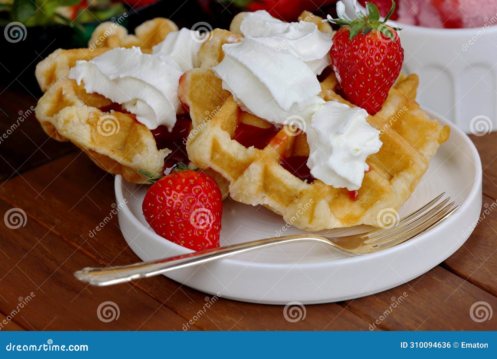 closeup of waffles with whipped cream and strawberries