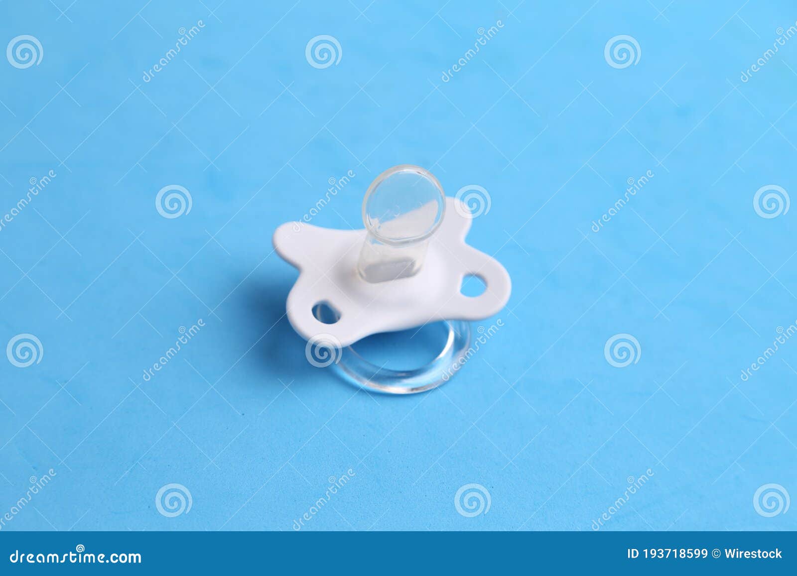 Closeup of a White Pacifier Isolated on a Blue Background Stock Image ...