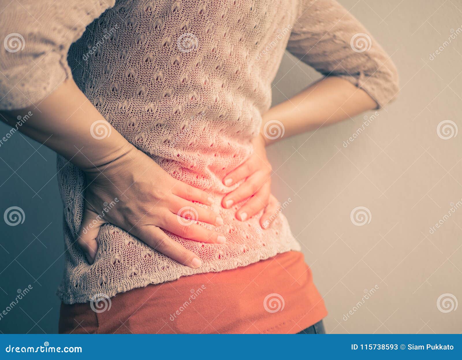 closeup woman with hands holding her waist back in pain.