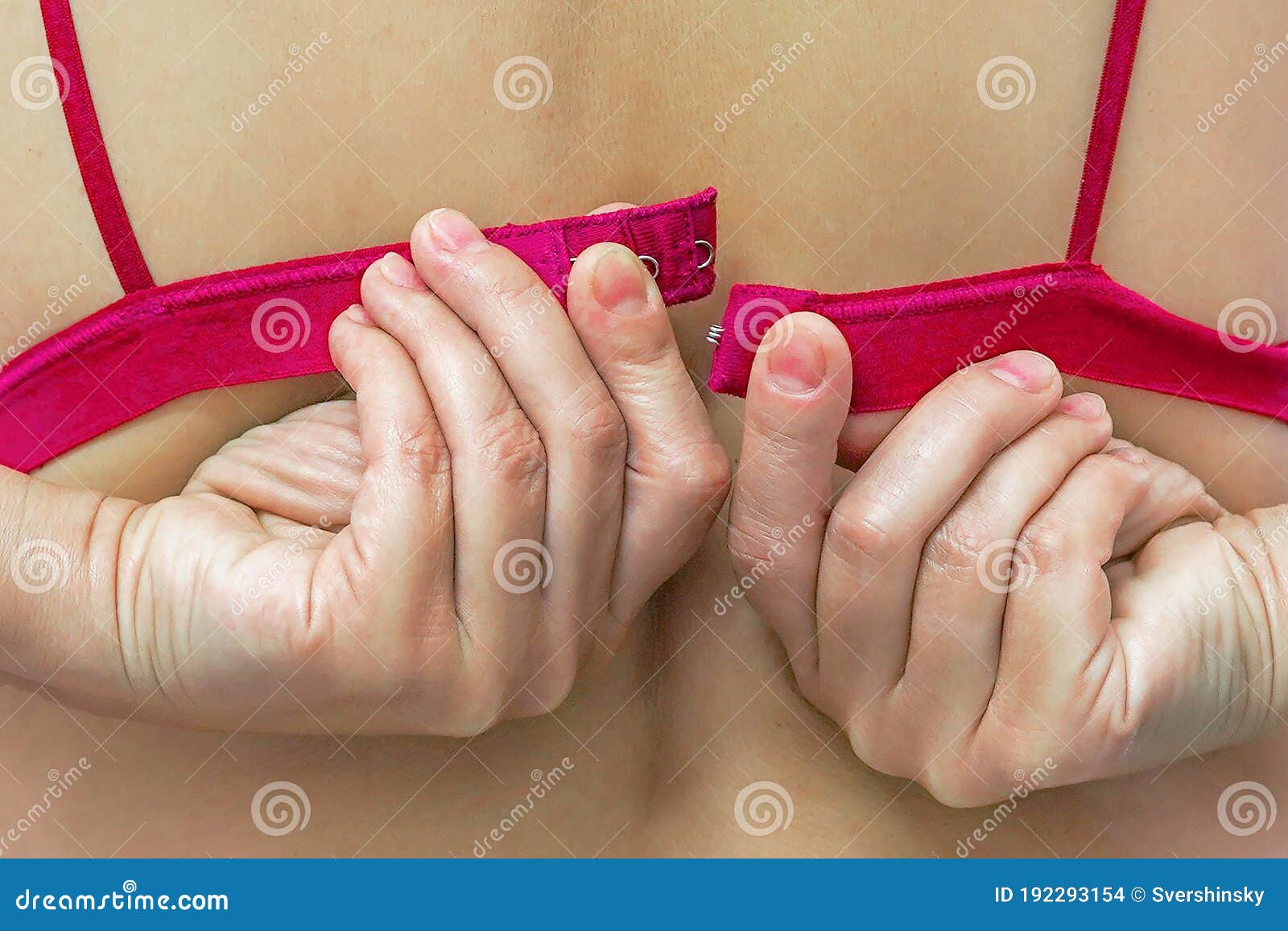female hands unfasten the red bra