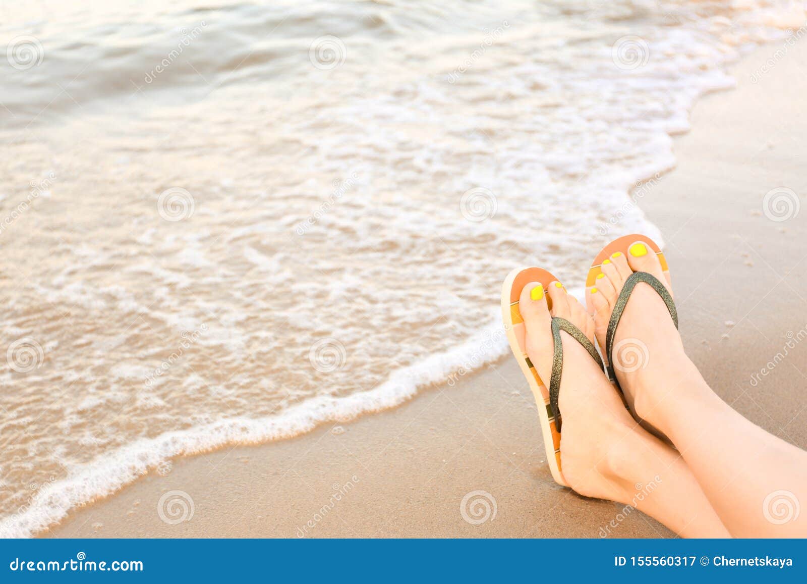 Closeup of Woman with Stylish Flip Flops on Sand Near Sea. Beach ...