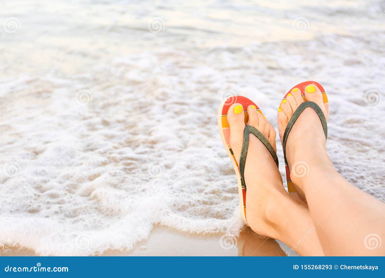 Closeup of Woman with Stylish Flip Flops on Sand Near Sea, Space for ...