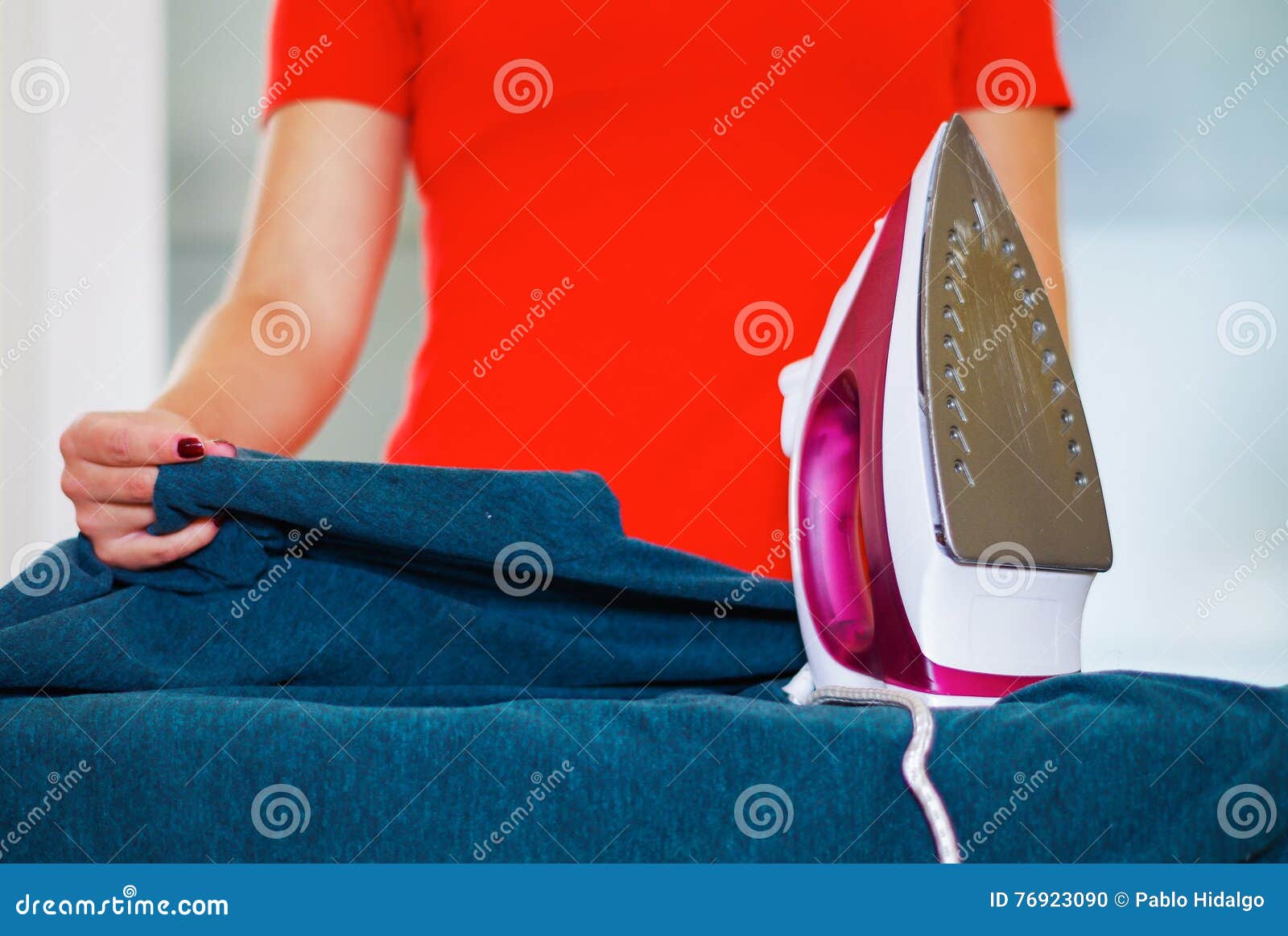 Closeup Womans Hands Using Ironing Device on Blue Fabric, Laundry