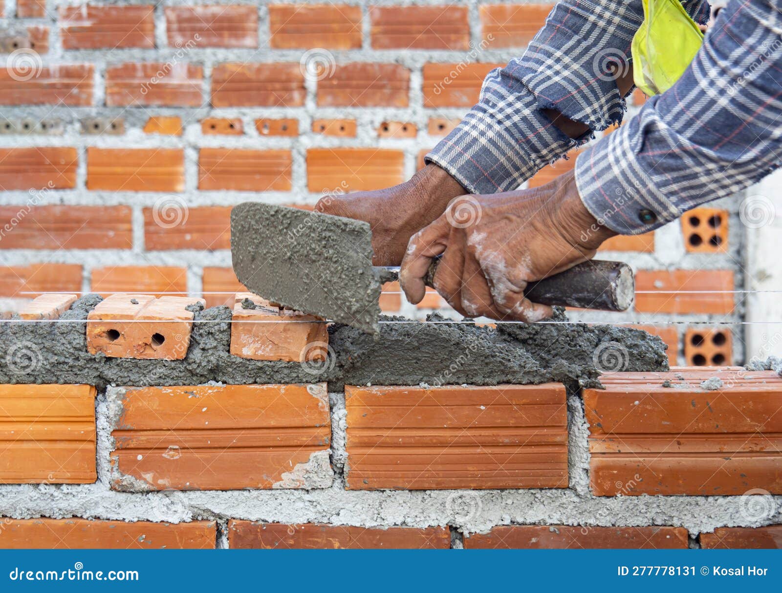 closeup of worker laying brick at construction site. masonary work, architectural work, under construction.