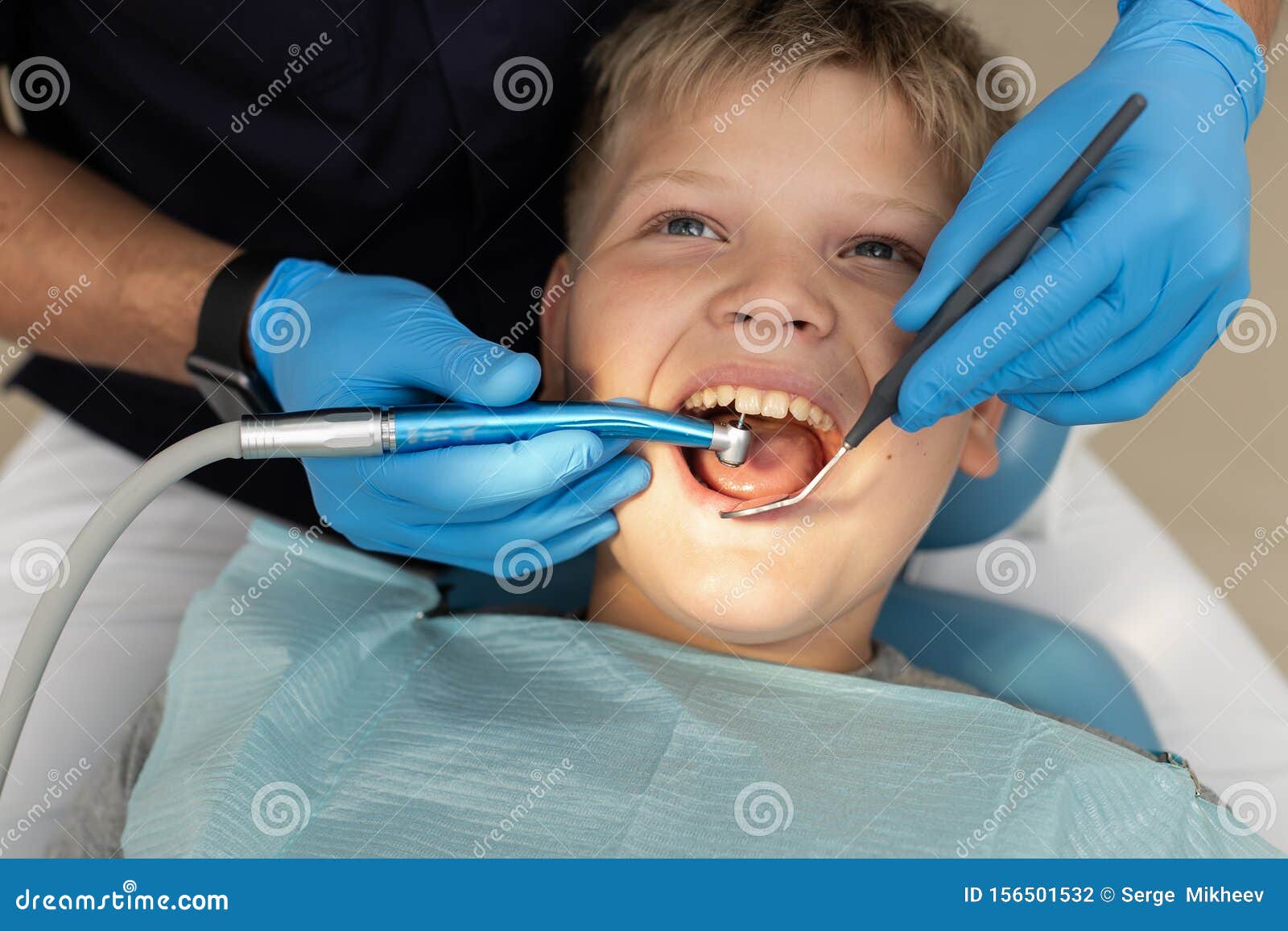Closeup of Young Boy`s Teeth Being Drilled by Dentist Stock Photo