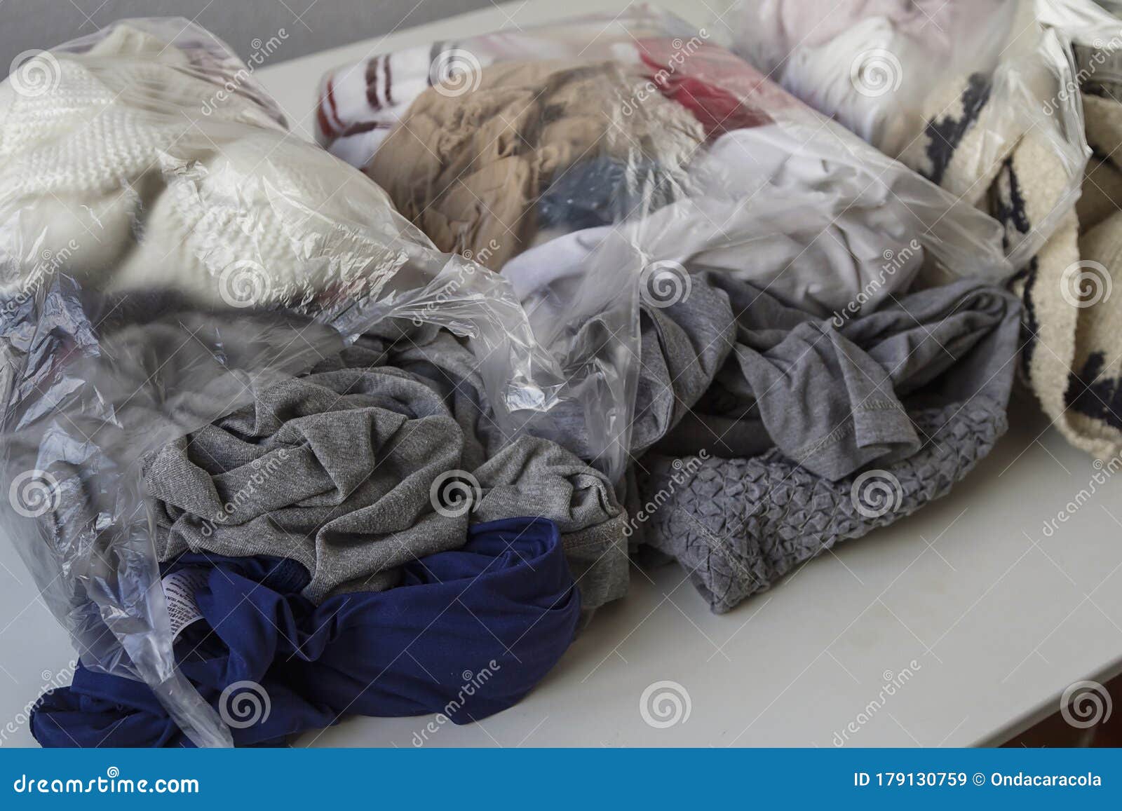 Clothes in plastic bags stock image. Image of concept 179130759