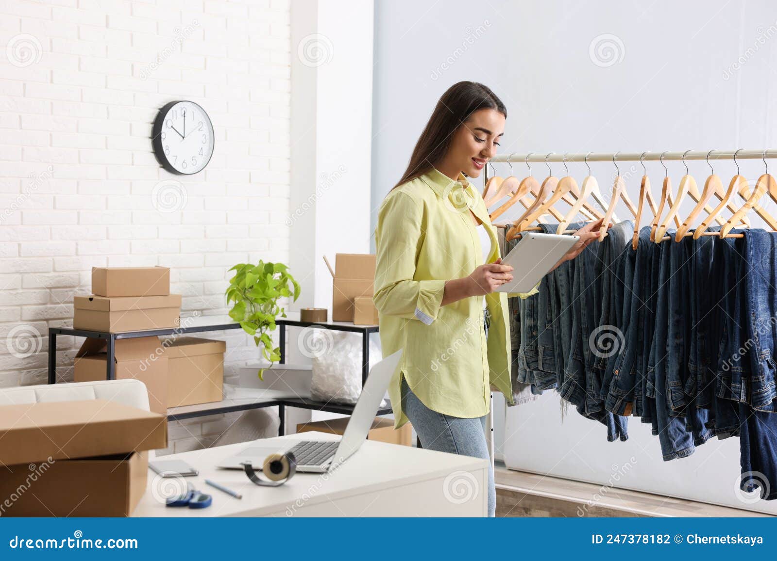Clothes Seller Working with Tablet in Office. Online Store Stock Photo