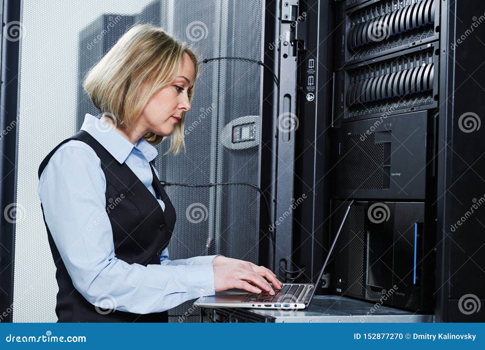 cloud storage service. female engineer works with laptop in data center