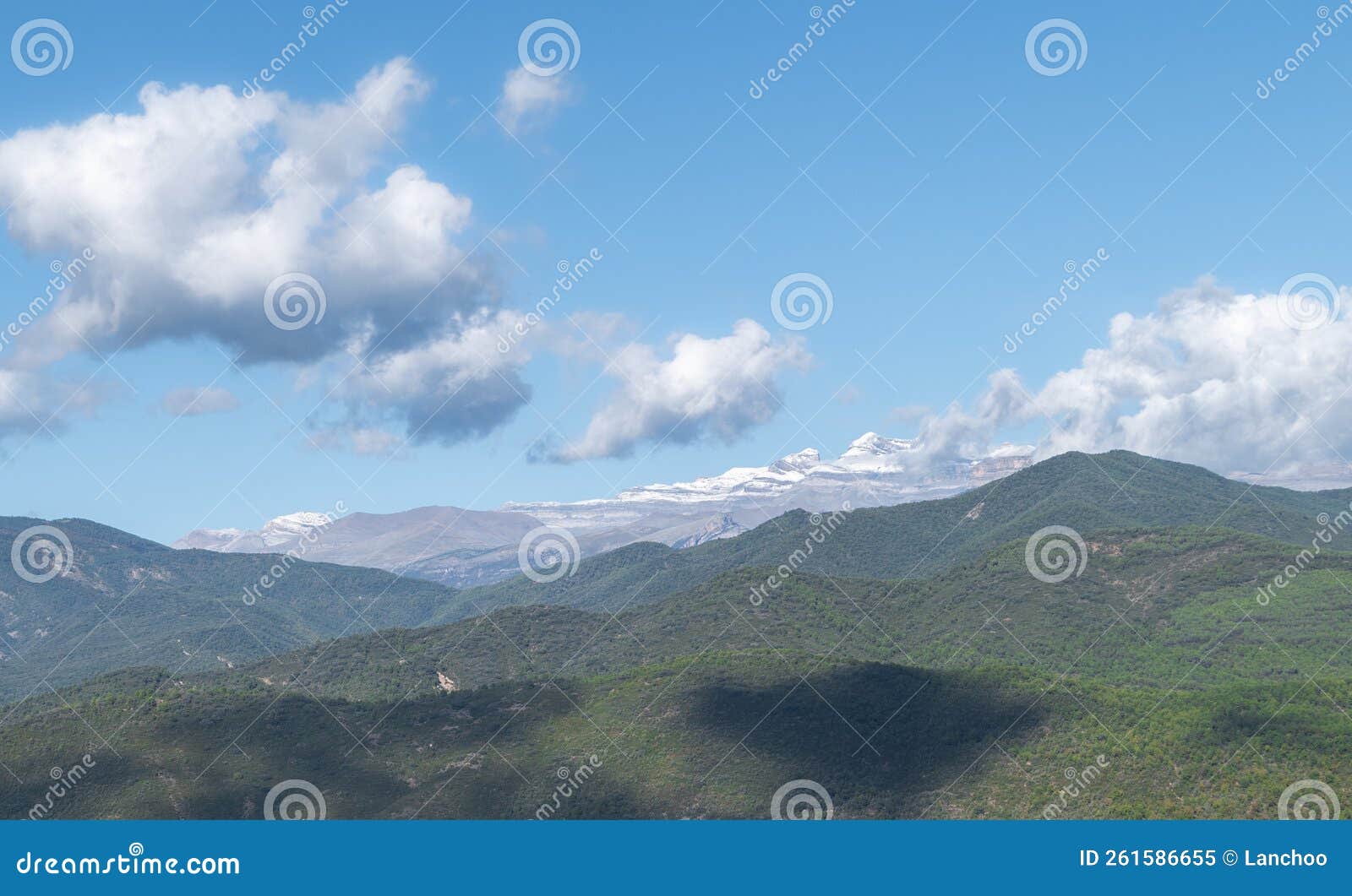 clouds above rolling green mountains