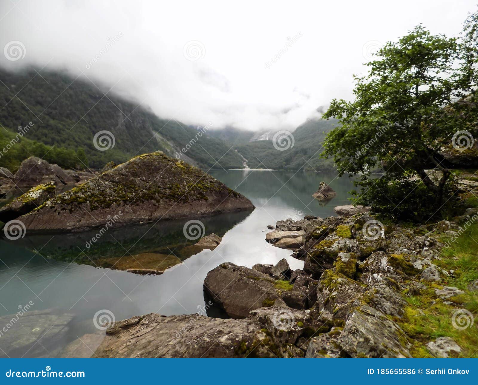 clouds and fog above the sharp shores of bondhusvatnet lake in folgefonna national park, norway