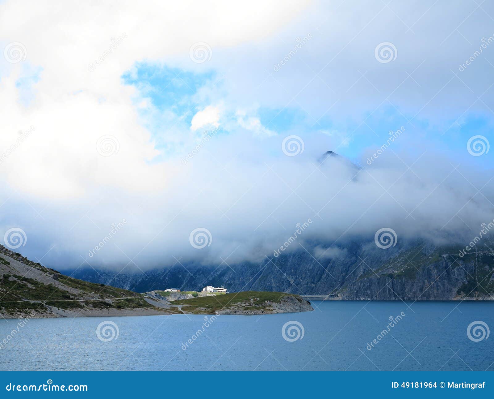 dammed mountain lake high alpine landscape in clouds
