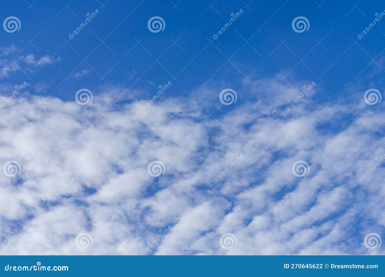 Fluffy white cloud, floating in clear blue sky