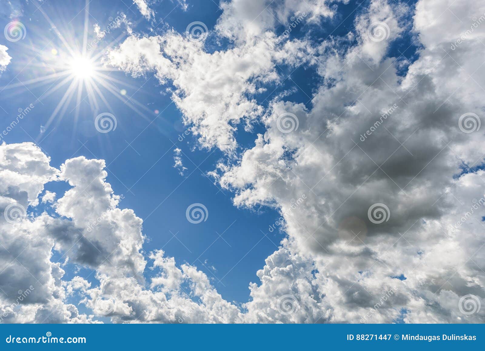 cloudy blue sky as background. direct sunlight, sun above the clouds