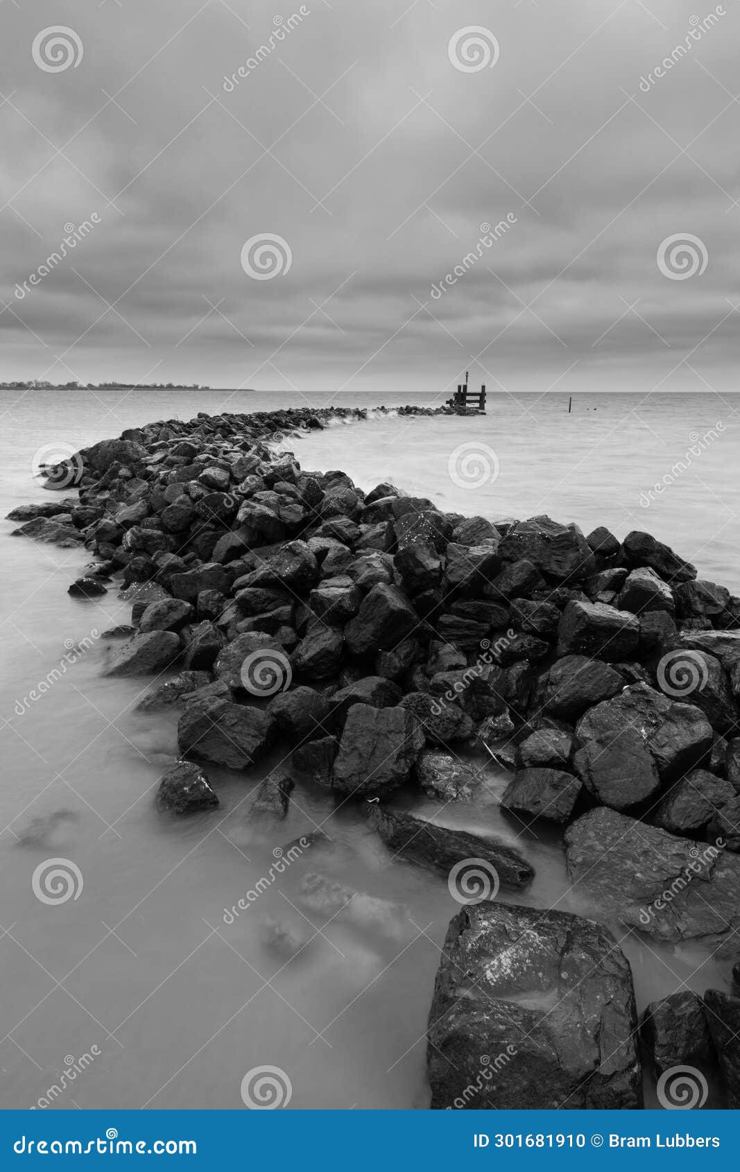 stone seawalls in markermeer (netherlands) withstand the storm and big waves with threatening clouds passing by. located in west-f