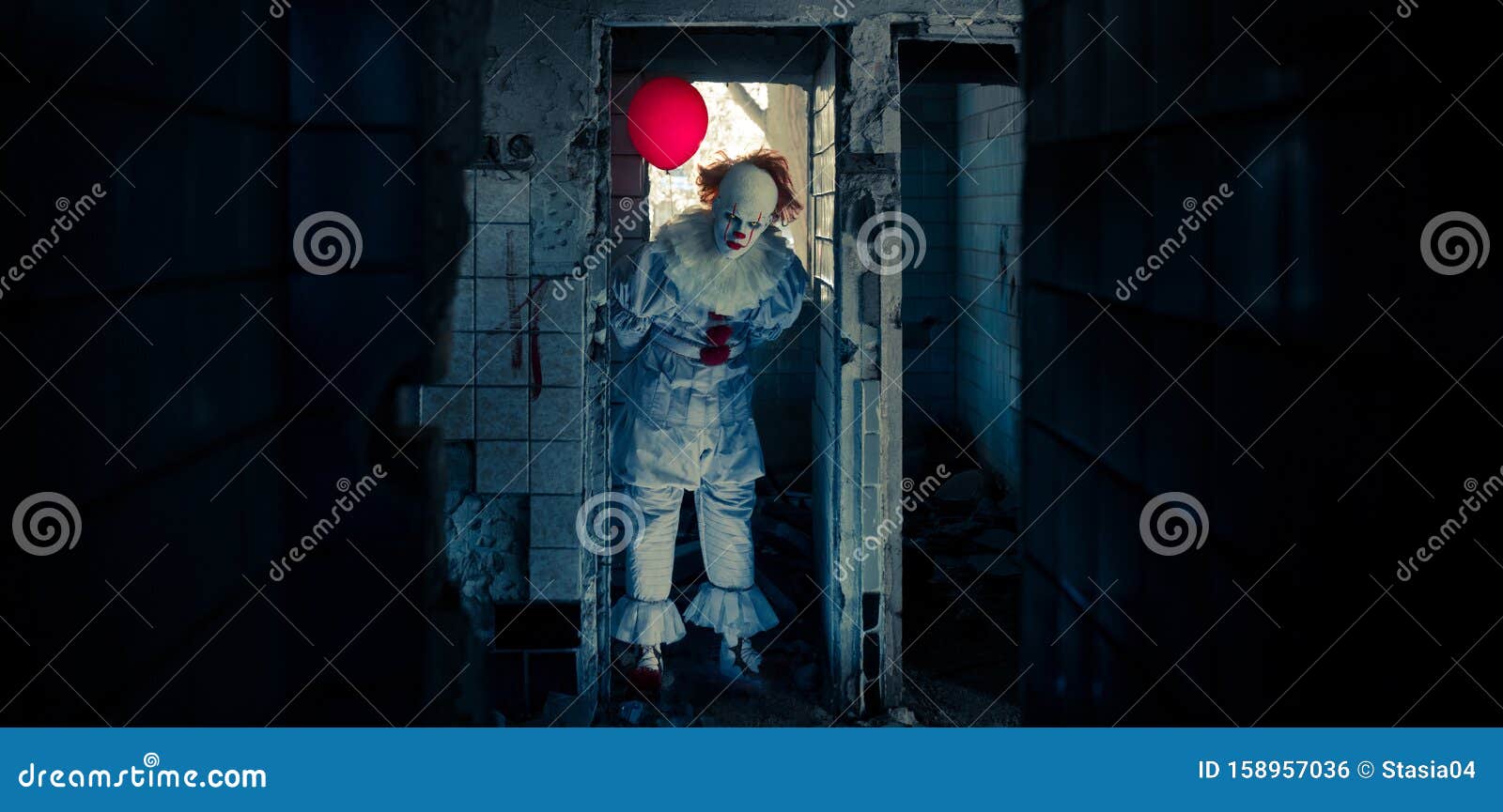 a clown with red balloon stands in old abandoned building