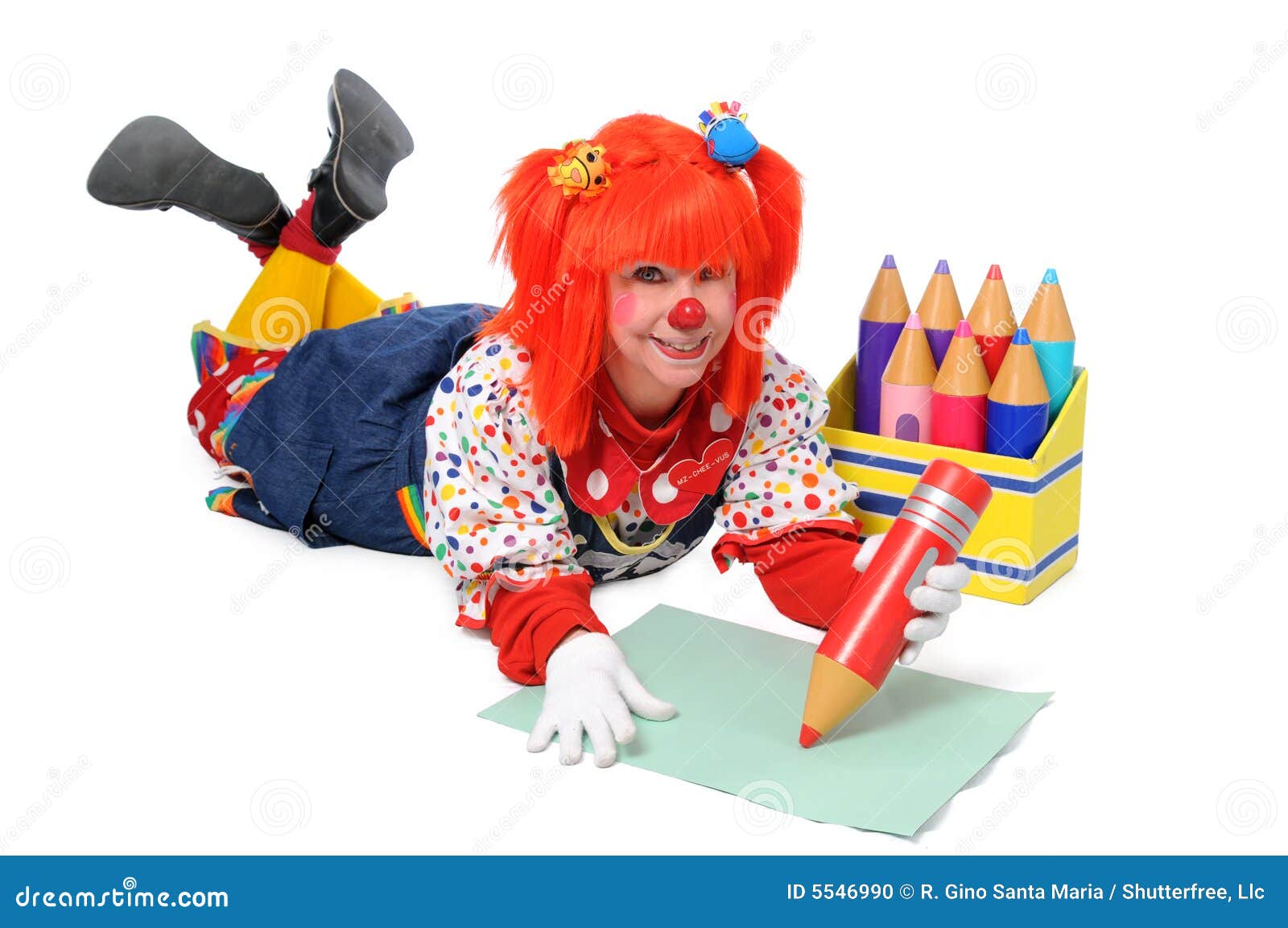 Clown établissant l'écriture. Clown fixant sur l'étage et écrivant avec de grands crayons de couleur