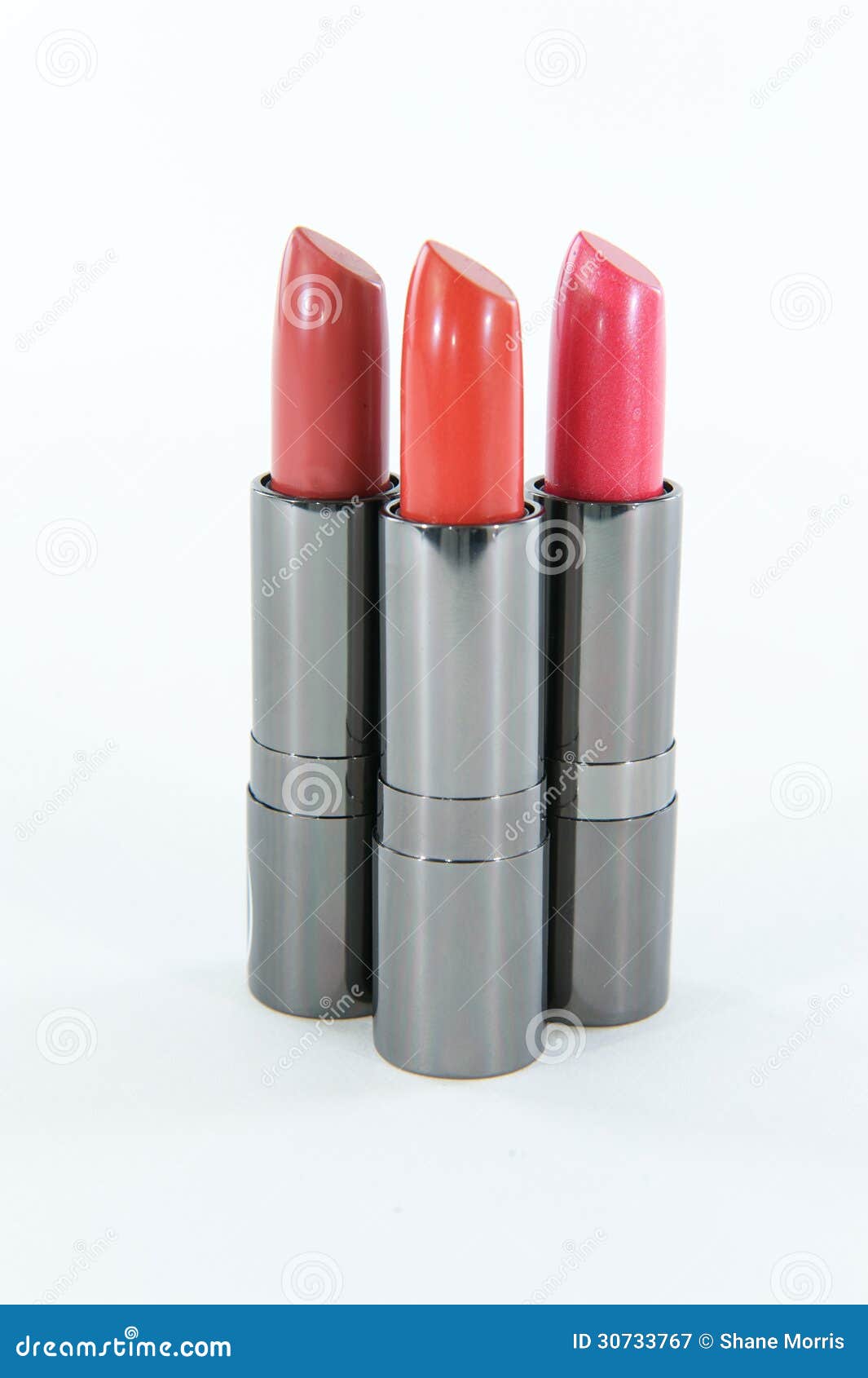 Cluster of Three Lipstick Cases Standing Against a White Background