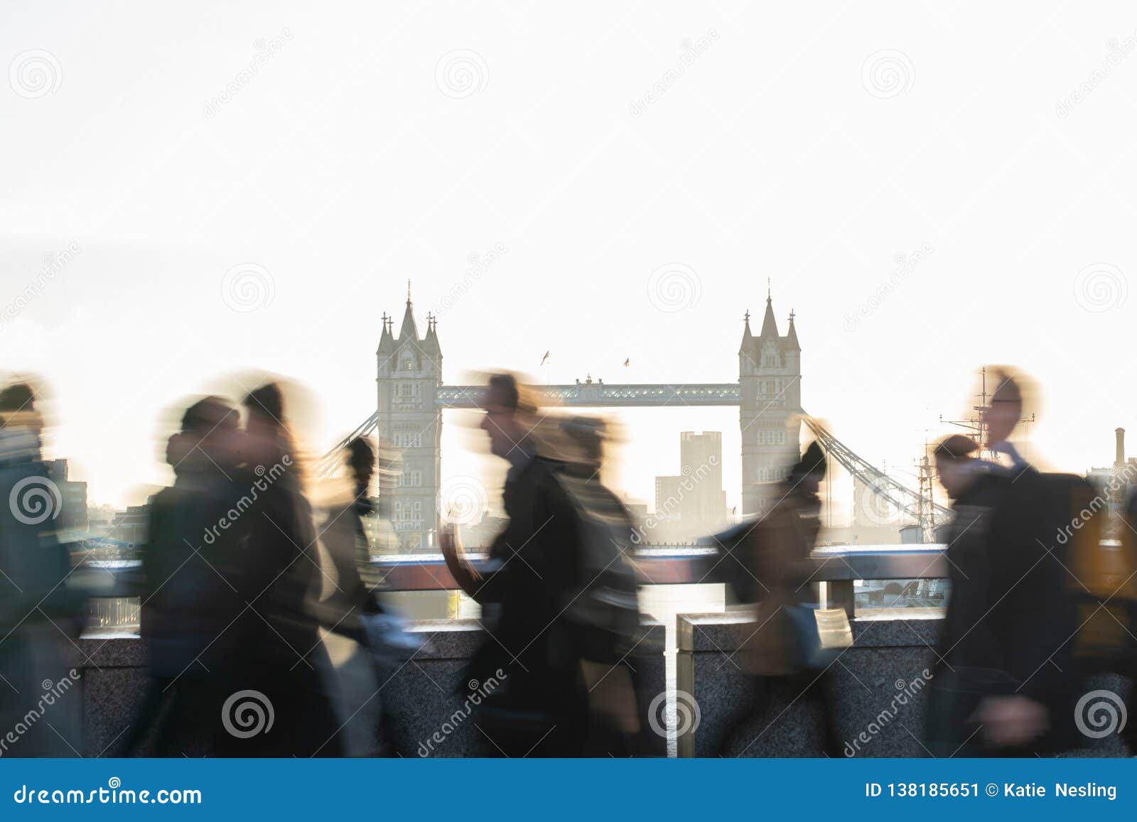 motion blur shot of commuters walking to work across london bridge uk with tower bridge in background