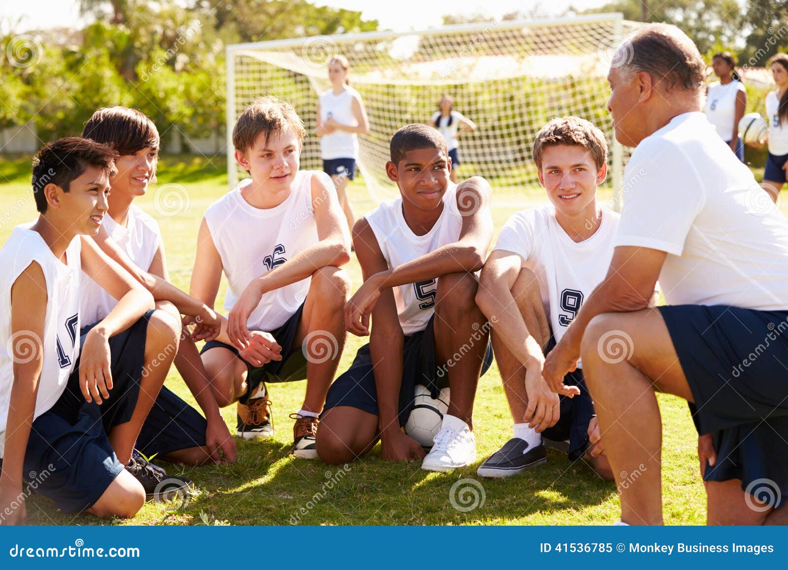 coach giving team talk to male high school soccer team