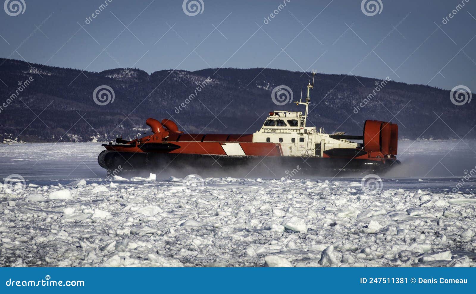 coast guard hovercraft breaking ice near a small community in eastern quebec, canada.