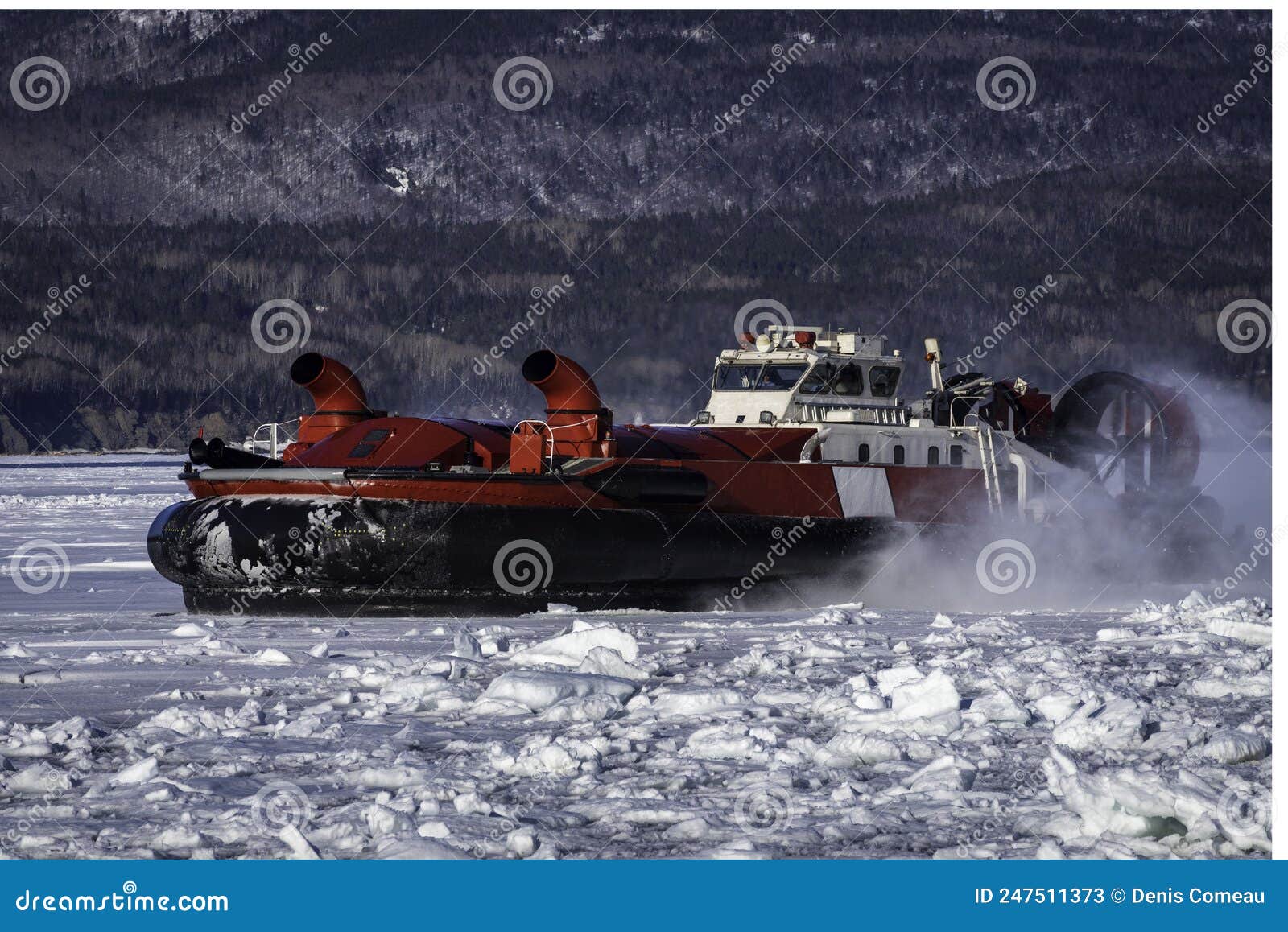 coast guard hovercraft breaking ice near a small community in eastern quebec, canada.